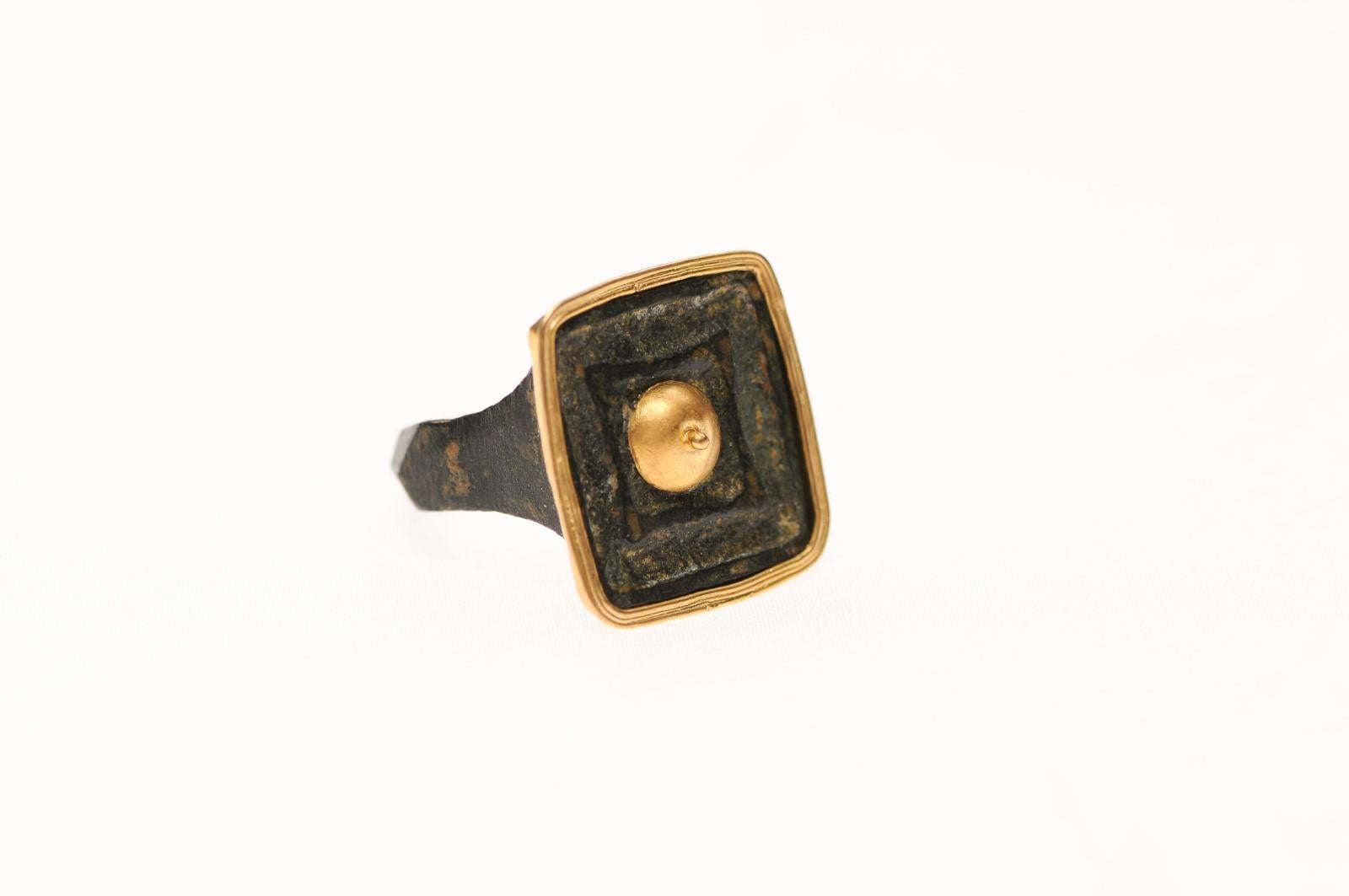 A bronze ring from the Ancient Roman Empire trimmed with 21K gold accents. There is a marvelous patina that demonstrates the ring's age. This is approximately from the 1st to 3rd Century AD and was created by lost-wax casting. This is a contemporary