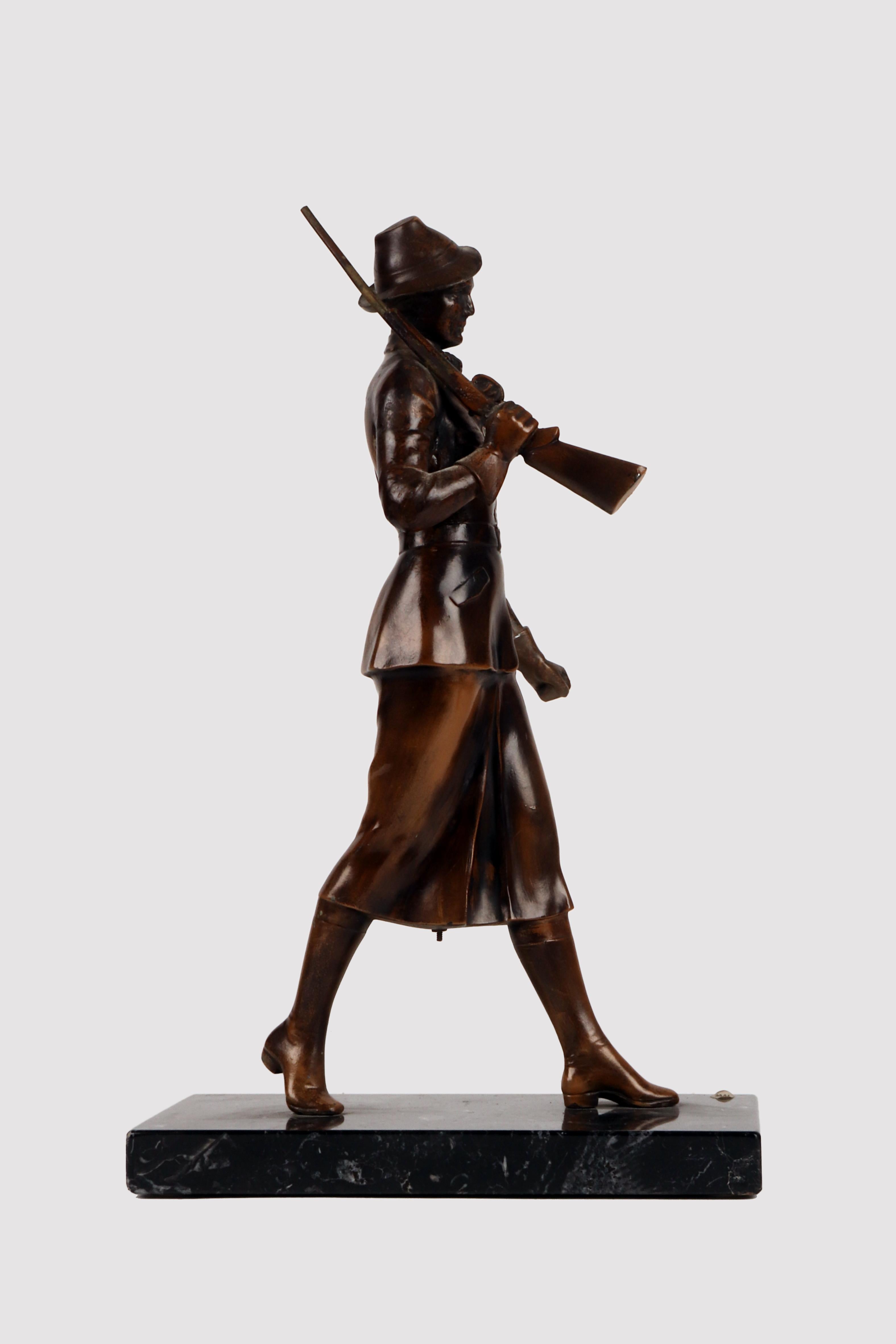 Bronzeskulptur, die eine Jägerin mit einem Gewehr auf der Schulter und einem Hut darstellt, mit einem Sockel aus geädertem schwarzem Marmor. Originale Patina. Österreich um 1920.