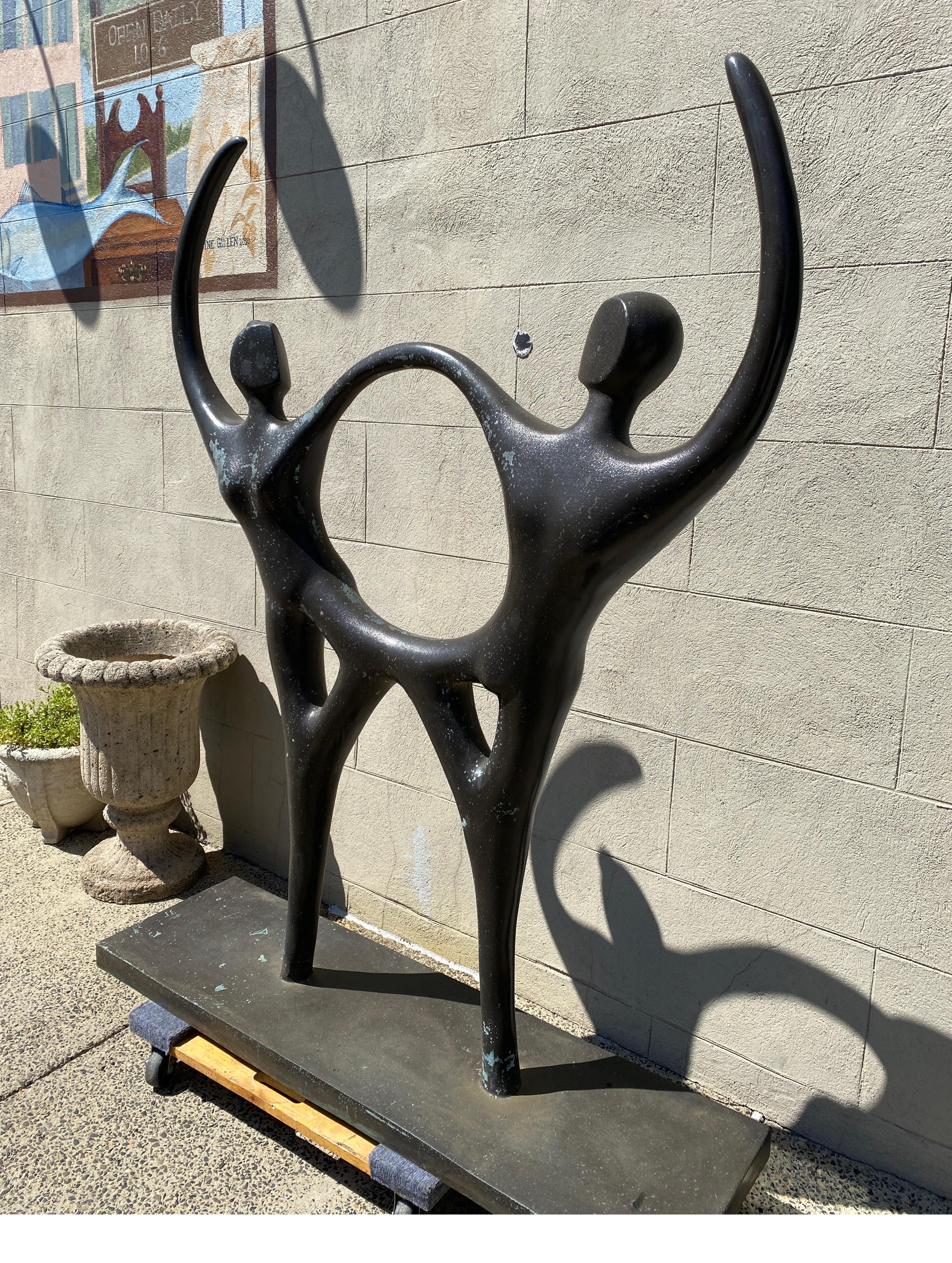 A Modern style cast bronze outdoor sculpture of a man and woman holding hands with knees touch, arms raised by Jose Almanzor (1962-2015), Titled 