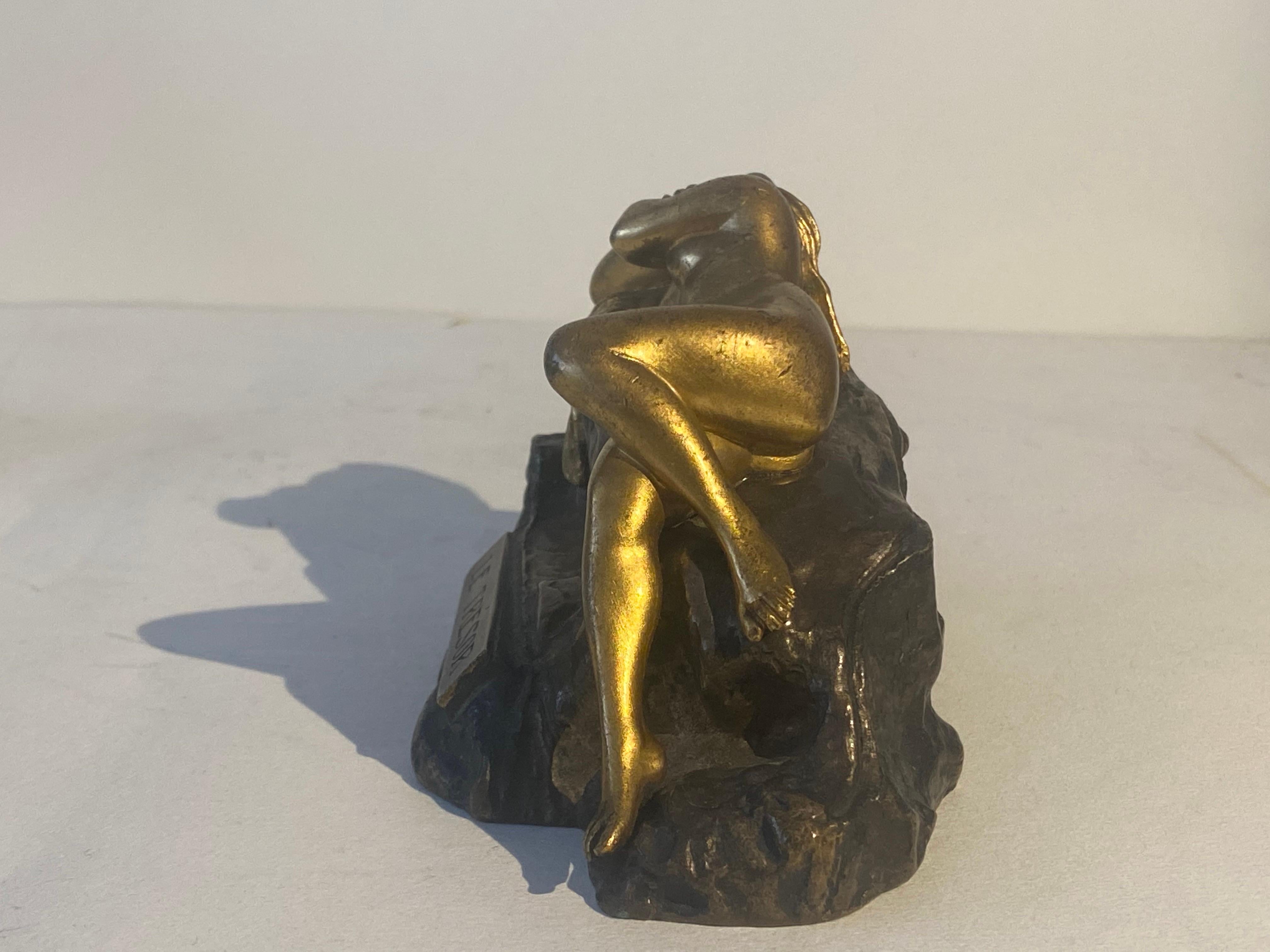 Asuperb quality early 20th century Austrian bronze study of a young man digging in search of treasure. The top of the bronze lifting to reveal the buried treasure of a reclining naked beauty in gilt bronze, exhibiting excellent hand finished detail