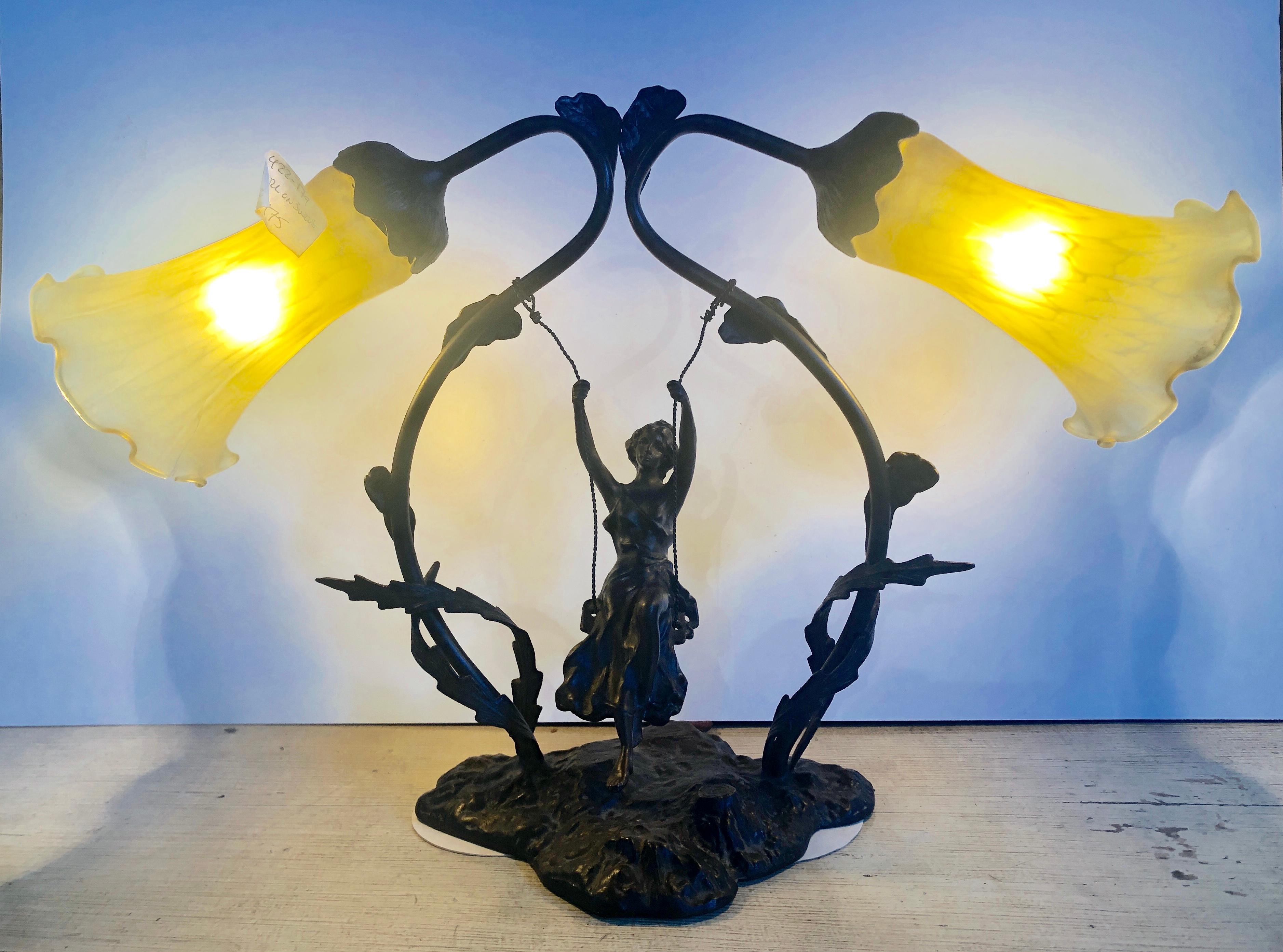Bronze signed S. Kestner table lamp os a young girl on a swing having two Tiffany Style glass shades.