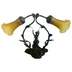 Lampe de table en bronze représentant une fille sur une balançoire avec un abat-jour en verre de style Tiffany