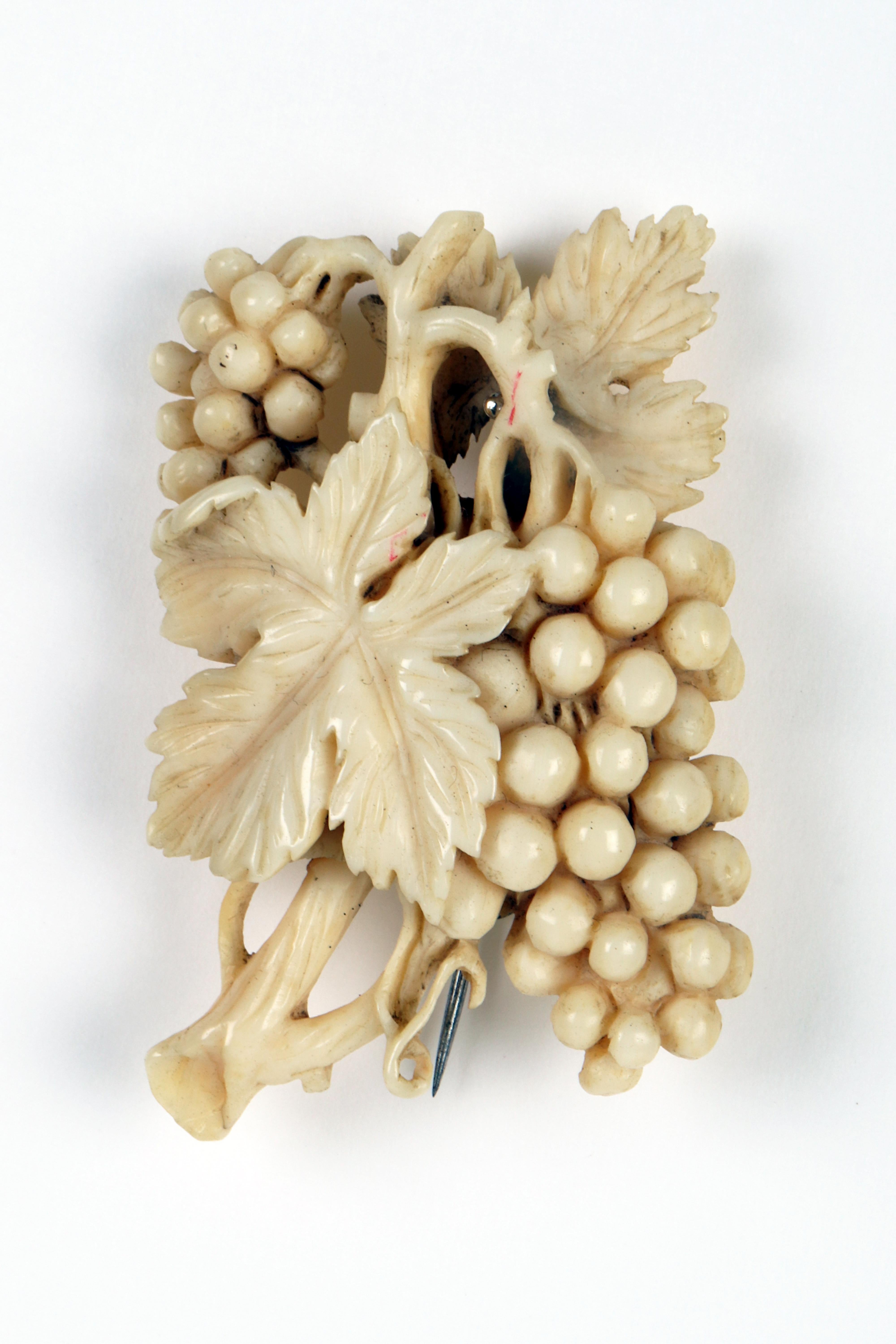 The brooch is finely made of carved and inlaid ivory depicting a grape branch with vine leaves and bunches, rich in movement and even minimal details. Deep three-dimensionality and mastery. England end of 19th century. (SHIP TO EU ONLY)
