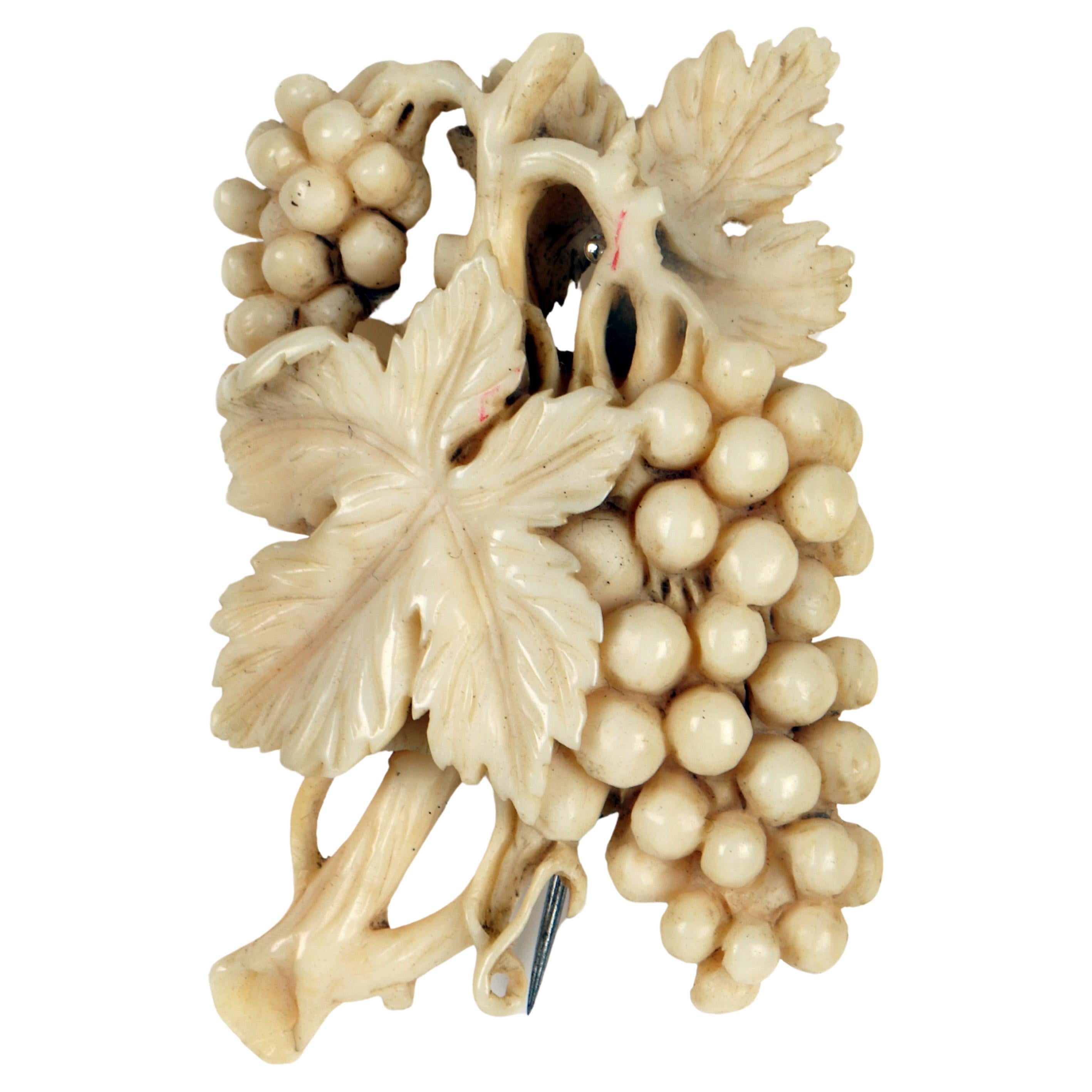 A brooch made of ivory depicting bunches of grapes, England 1890.