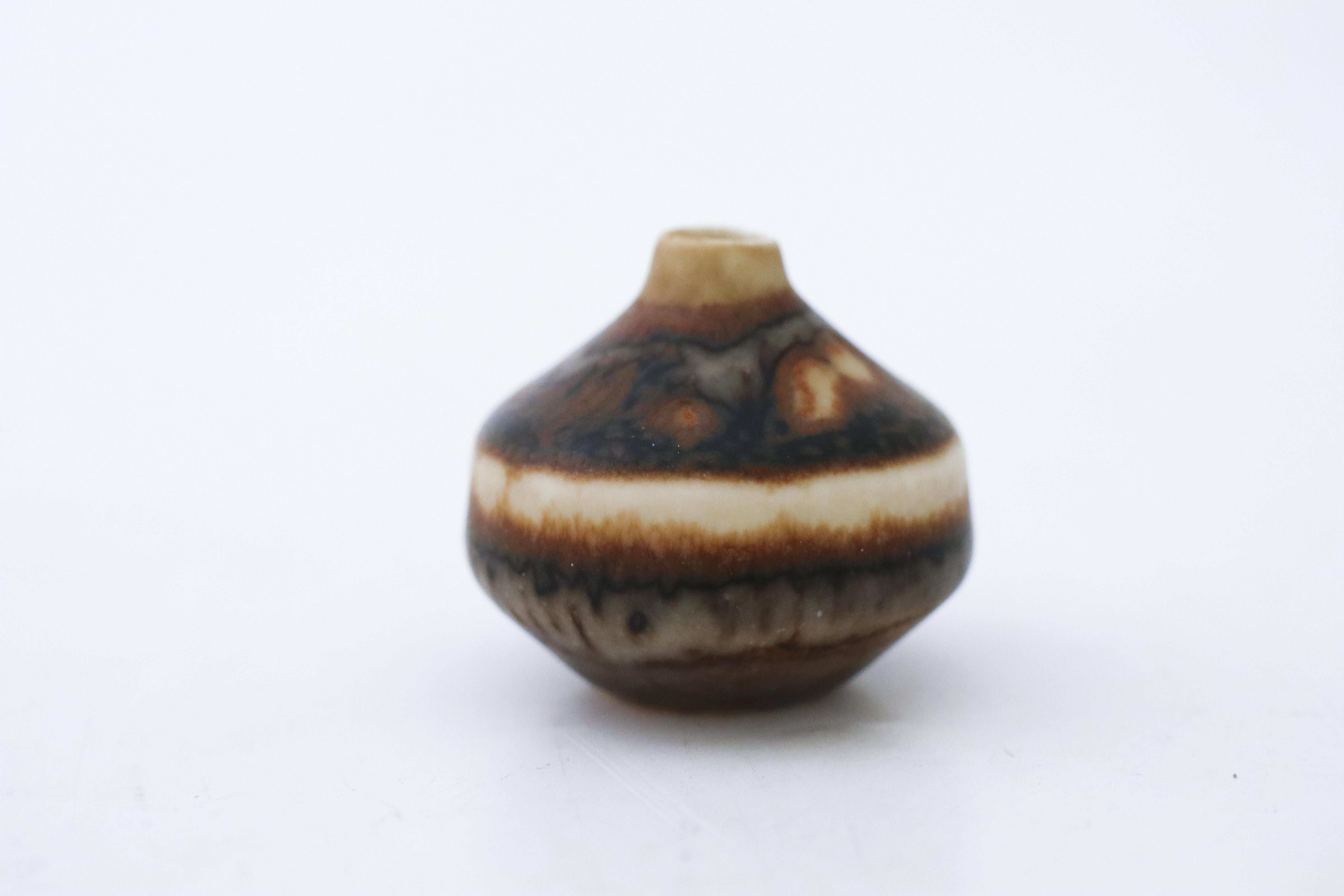 Un vase miniature brun conçu par Carl-Harry Stålhane à Rörstrand, d'une hauteur de 3,5 cm et en très bon état, marqué comme étant de 1ère qualité. 

Carl-Harry Stålhane est l'un des grands noms de la céramique scandinave du milieu du siècle. Il a