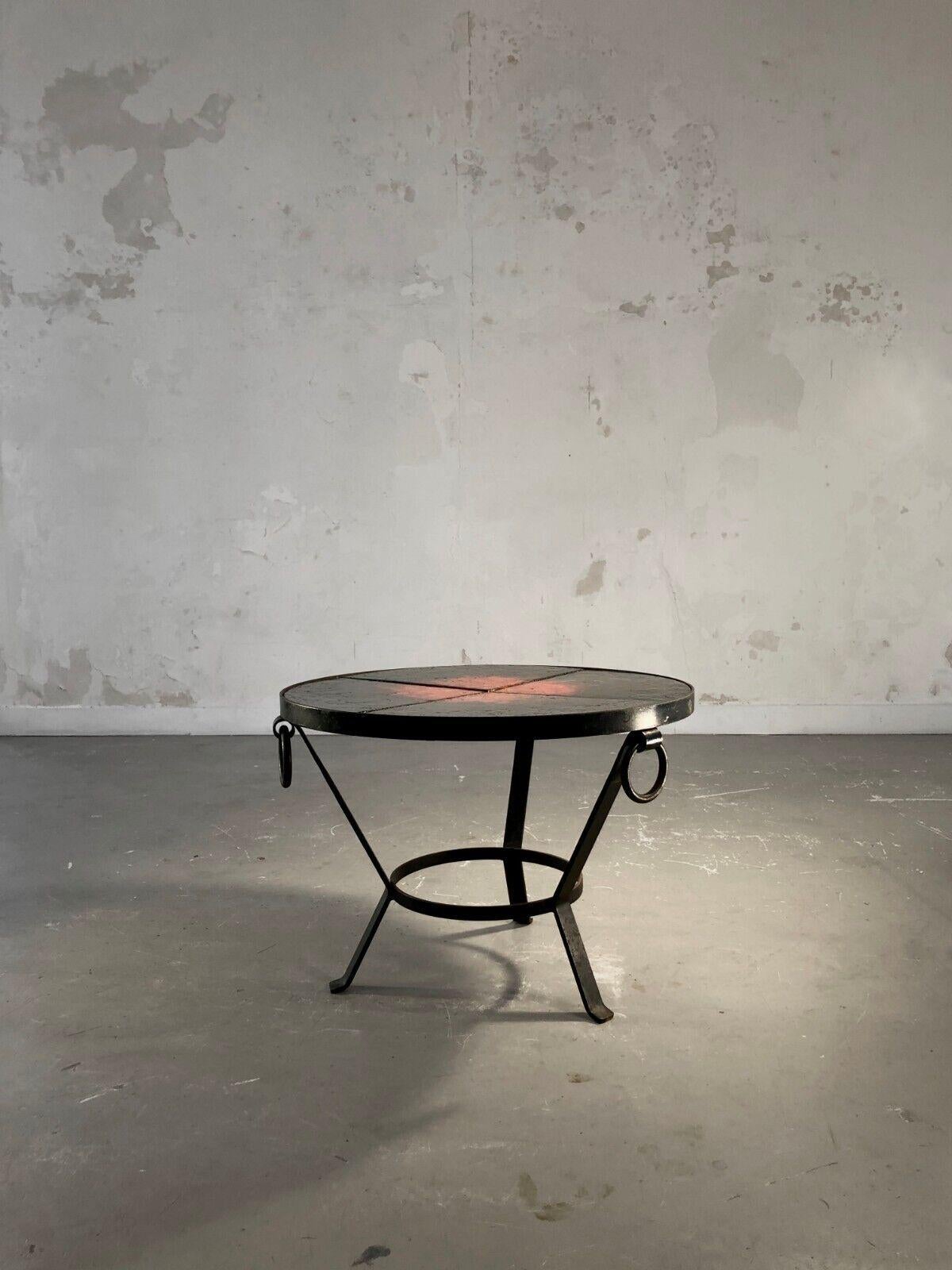 A rigorous coffee table or low tripod pedestal table, bedside or end table, Modernist, rigorous black wrought iron structure, circular top in enameled lava stone with superb glowing decoration on a black background of volcanic inspiration, made in 4