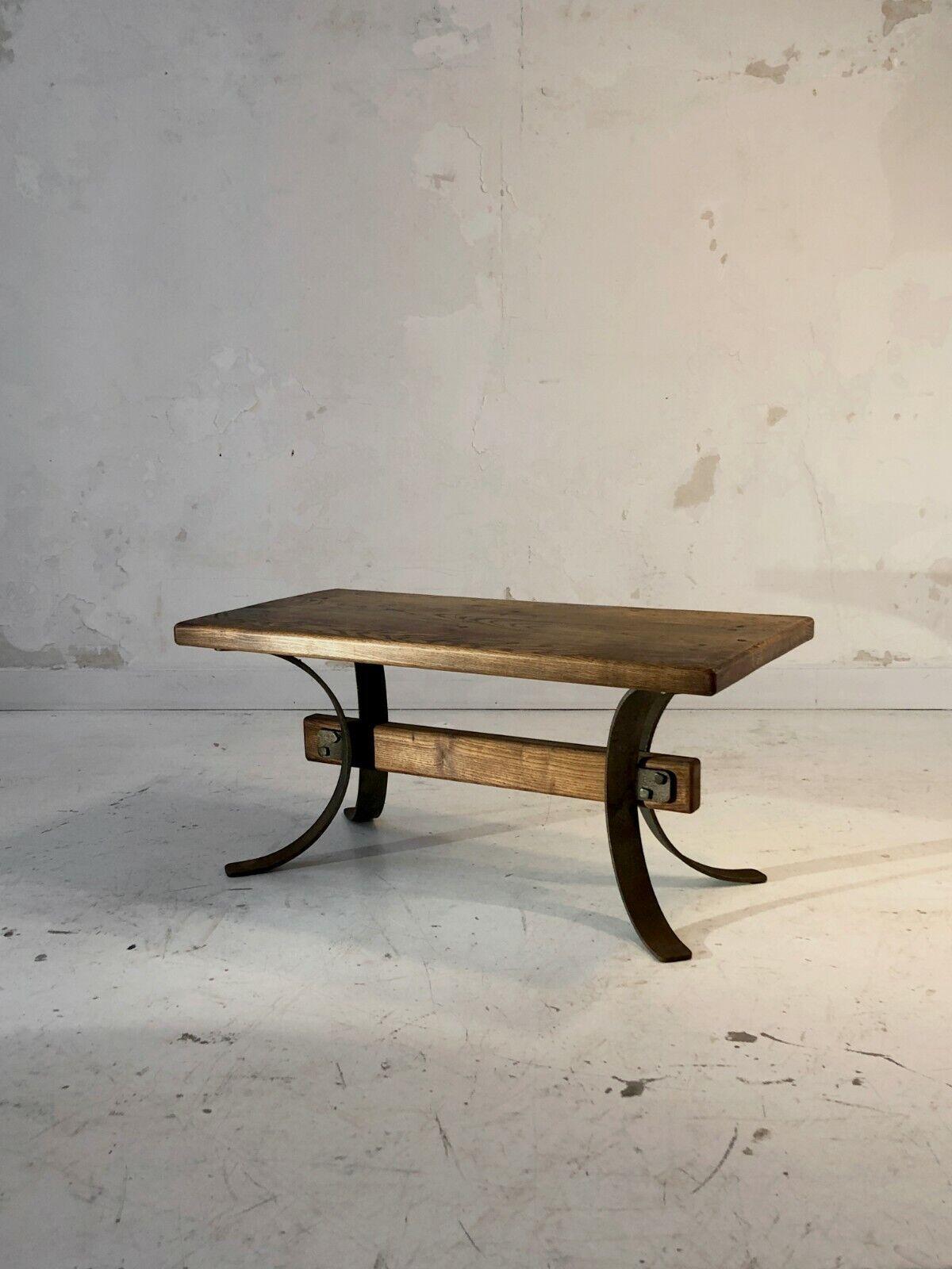 An astonishing coffee table both raw and sophisticated, massive and airy, Modernist, Brutalist, Popular Art, Free Form, powerful ironwork structure offset by legs with curved lines with a seventies look, and oak crossbar and top massive, to be