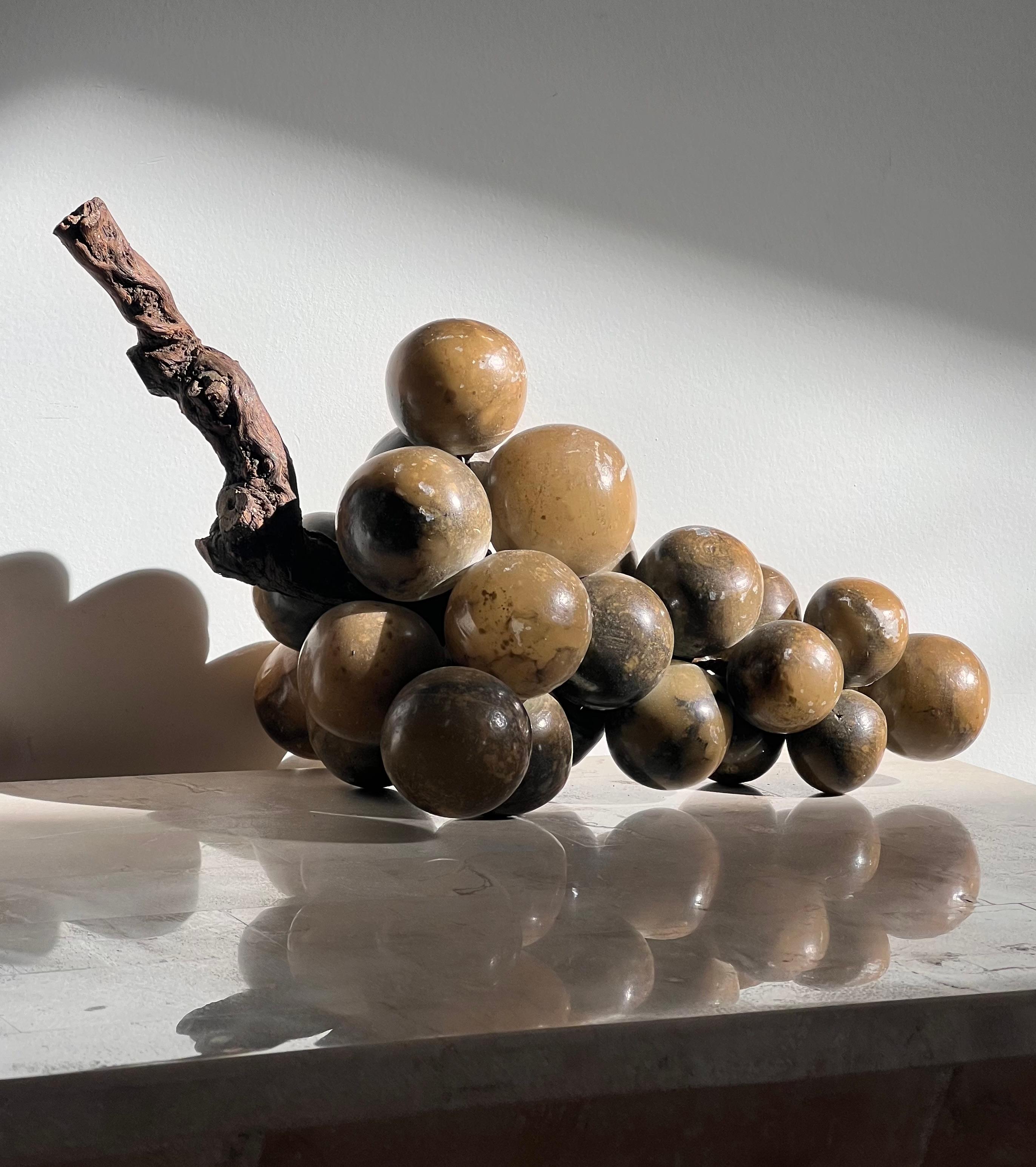 A bunch of monumental “jumbo” grapes sculpted from Italian alabaster, mid twentieth century. With live raw root wood stem. The grapes themselves are in varying tones of olive green. 