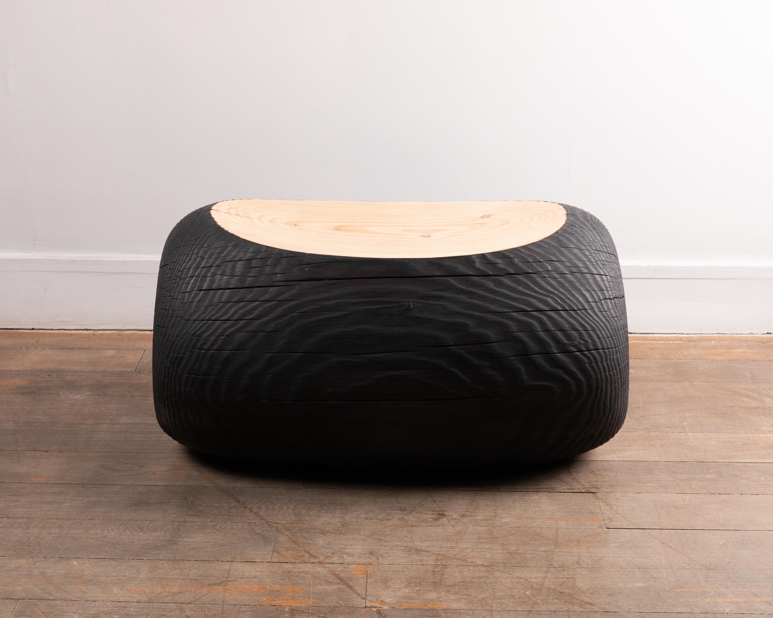 A burnt wood bench made of Douglas pine.
The wood of the excavated trunk is burned in contrast with the seat, which shows the natural light color and grain of the wood.
Organic modern style. 
Contemporary production by François