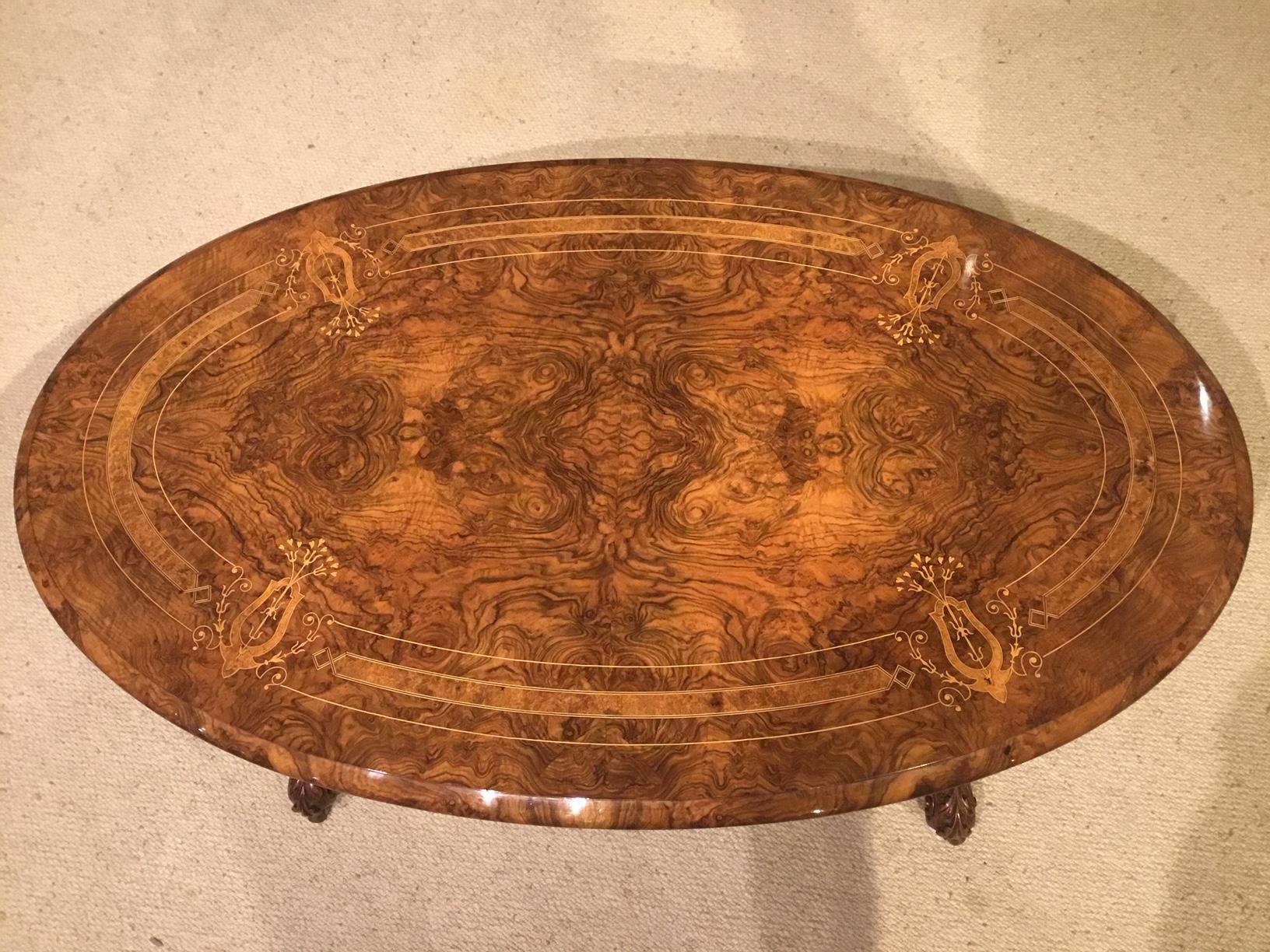 A superb quality burr walnut marquetry inlaid Victorian period antique coffee table. Having an oval top veneered in beautifully figured burr walnut with an amboyna and boxwood inlaid border and fine floral marquetry panels. Supported on four turned