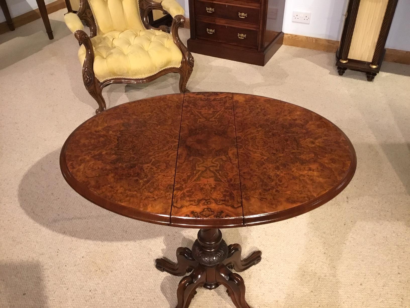 A burr walnut Victorian period drop leaf Sutherland table. Having an oval top veneered in beautifully figured burr walnut with two drop leaves and a concealed mahogany lined drawer to each end. Supported on a spiral twist and carved column with four