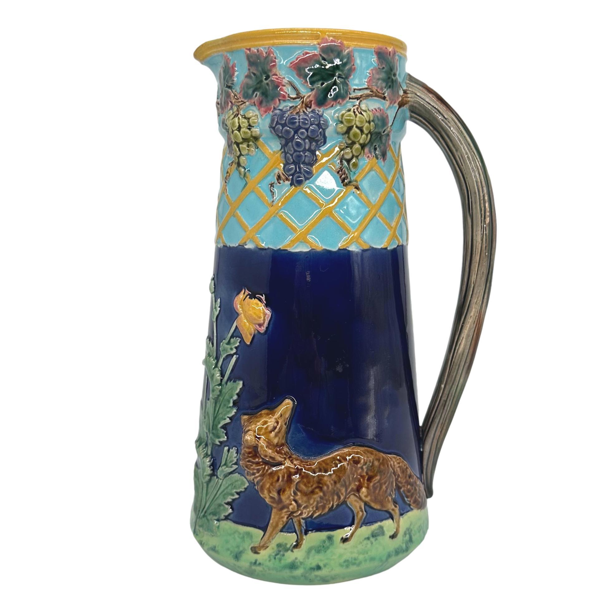 T.C. Brown-Westhead, Moore & Co. Majolica Jug Depicting 'The Fox and the Grapes from Aesop's Fables, with a molded and applied fox to each side and glazed in deep cobalt blue, the top portion with yellow trellis-work laden with colorfully glazed