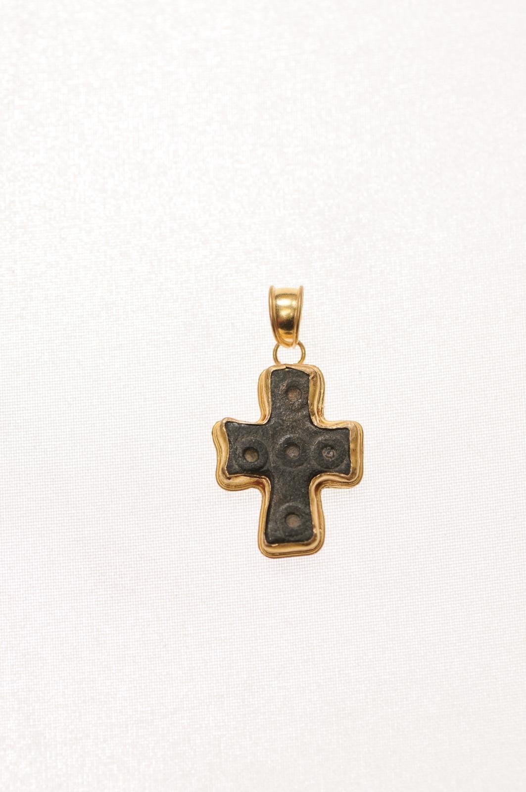 Une croix en bronze de l'époque byzantine abondamment garnie d'or 21 carats. Cette croix en bronze a été créée à l'origine par moulage à la cire perdue et les accents circulaires ont été ciselés à la main. L'ère byzantine s'étend des années 300 à la