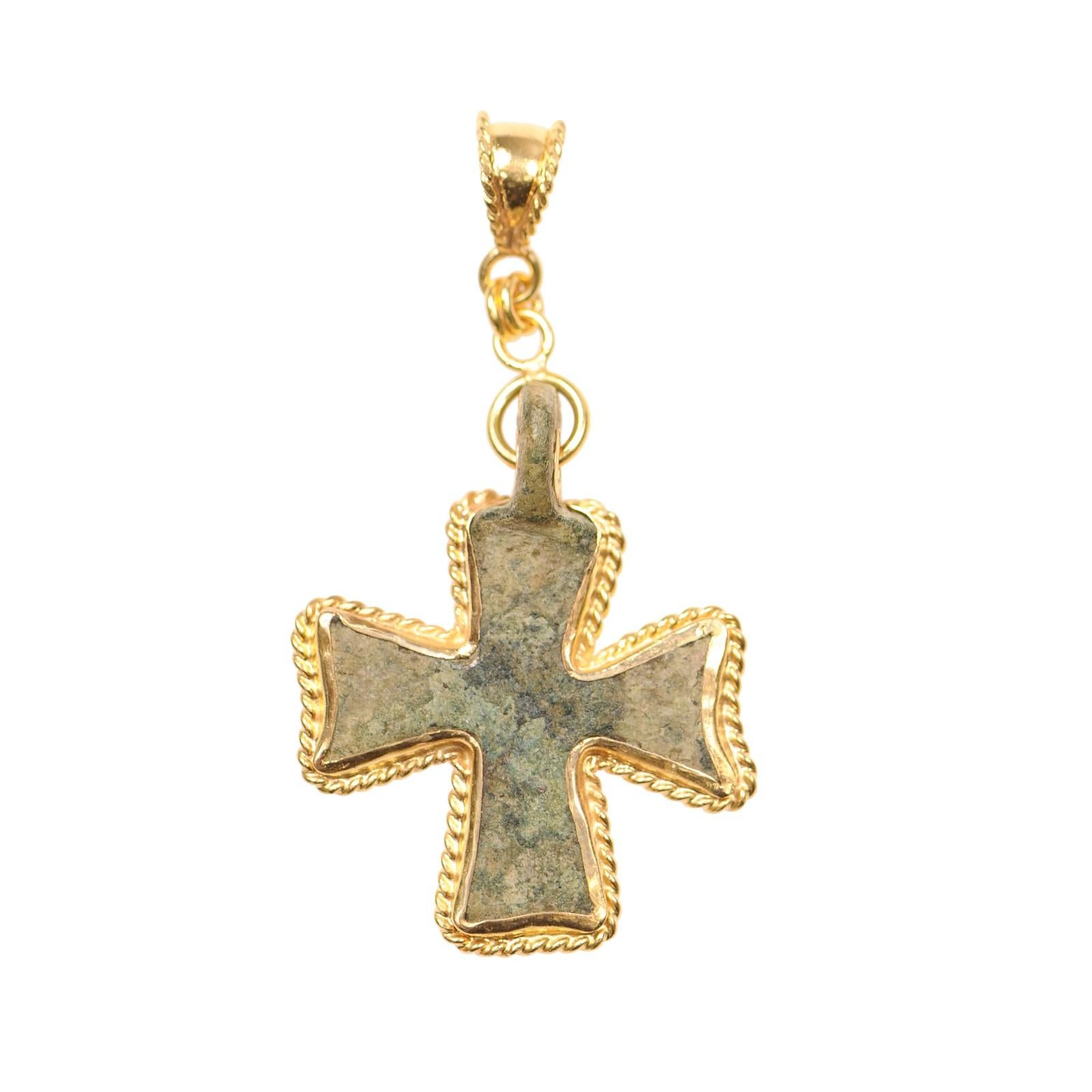 Ciondolo a forma di croce bizantina con incastonatura a penzoloni in oro 21 carati e rifiniture in corda intorno ai bordi. Questa croce in bronzo risale al IV-VI secolo d.C.; probabilmente è stata creata con una fusione a cera persa e poi le