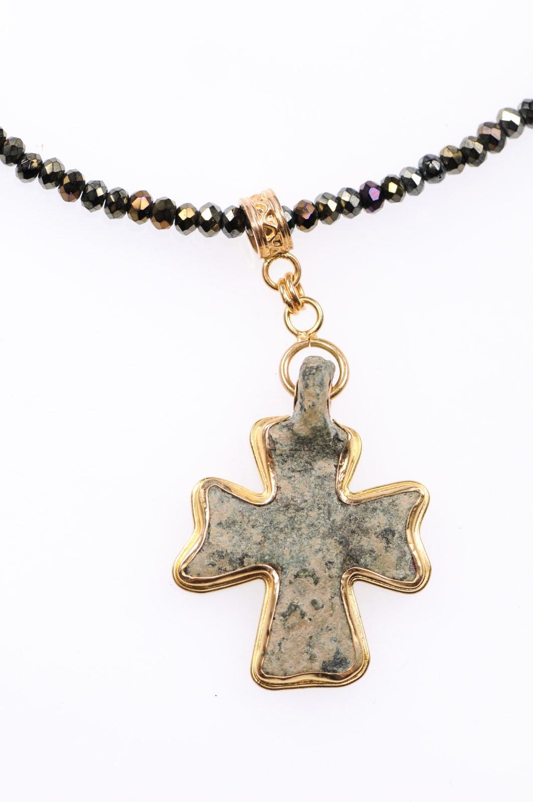 An authentic Byzantine era bronze cross, (4th-6th century AD), with the contemporary addition of the 21-karat gold bezel. This ancient Byzantine cross of bronze has a rich, green patina and is set in a custom 21-karat solid gold pendant with hanging