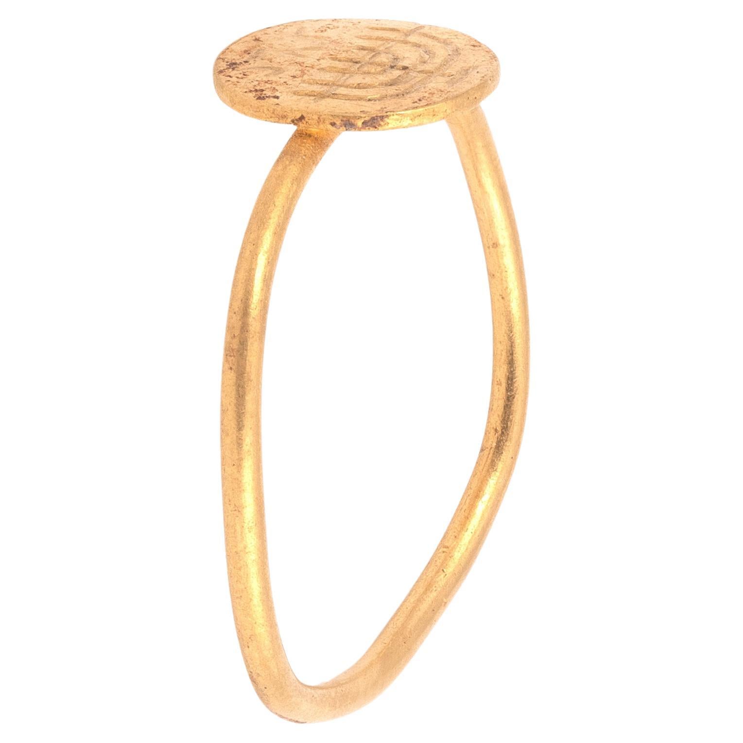 Ein byzantinischer Goldring mit einer jüdischen Menora und einer Inschrift. Ein typischer frühbyzantinischer Ring aus gelötetem Draht mit rundem Querschnitt und runder Lünette, graviert mit einem Kandelaber für sieben Lampen und drei