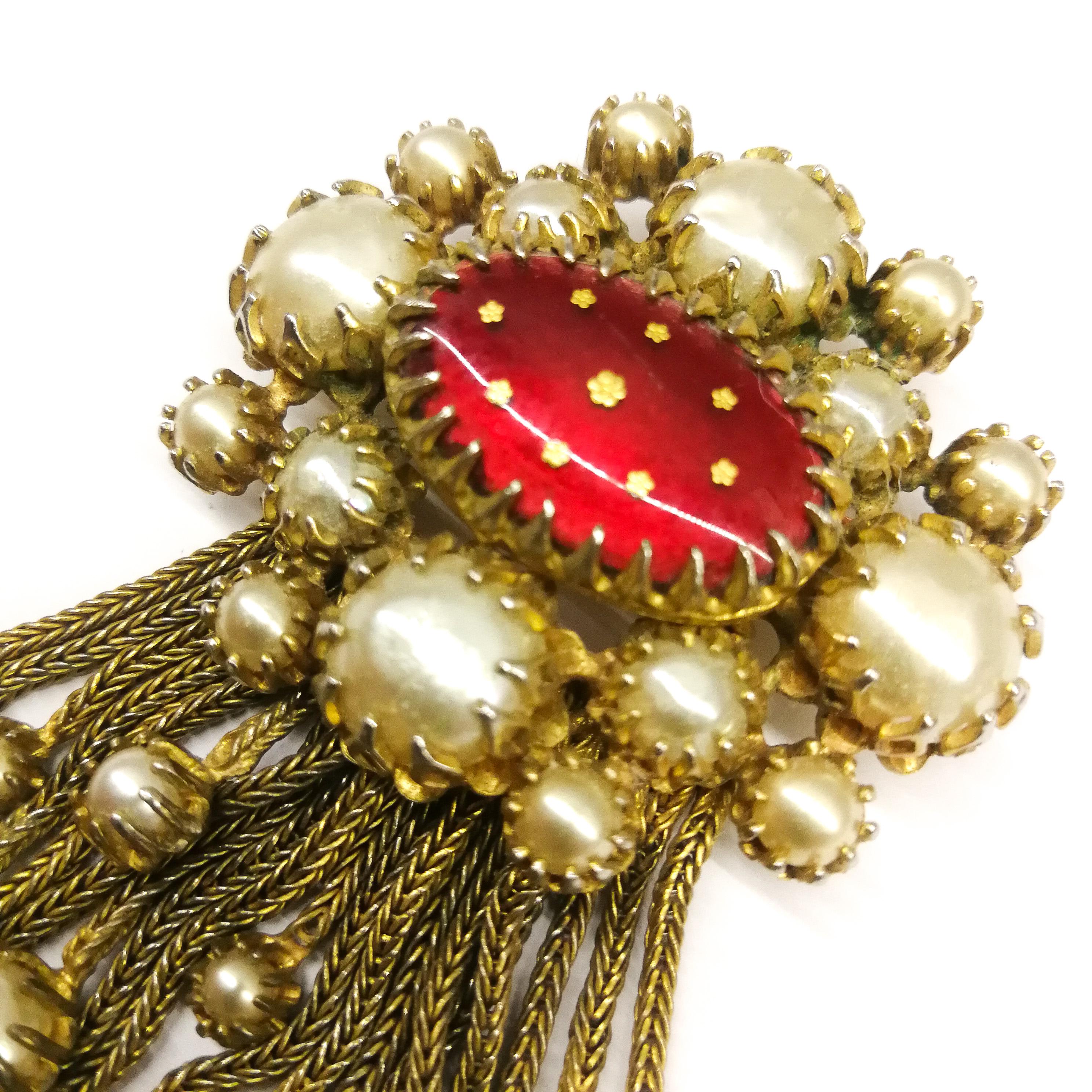 A rare and well known design by Mitchel Maer for Christian Dior, this brooch is a fine example of the Byzantine influence on the designers at this time. Made of softly gilded metal and baroque cabuchon paste pearls, a plaque of red and gilt Limoges