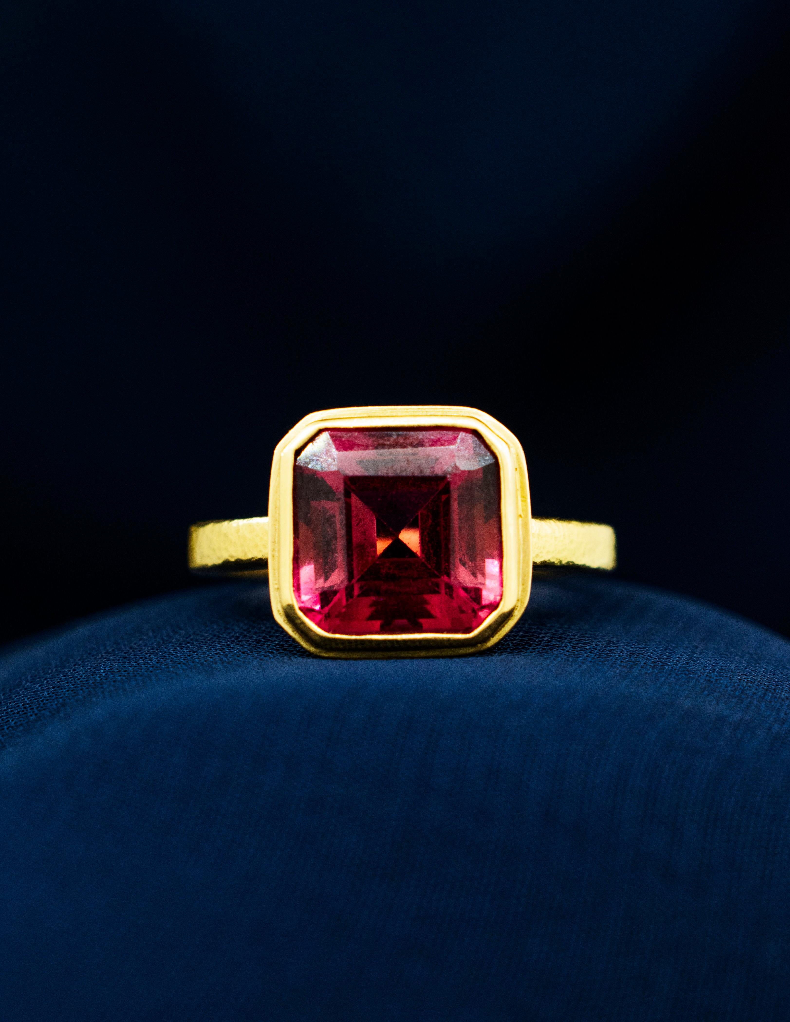 Anillo Bizantino de Oro Amarillo de 18 quilates con una Turmalina Rosa Profunda engastada en bisel. La Turmalina Rosa es de talla Asscher modificada y pesa unos 4,00 quilates. La piedra es brillante y está relativamente libre de inclusiones. 
La