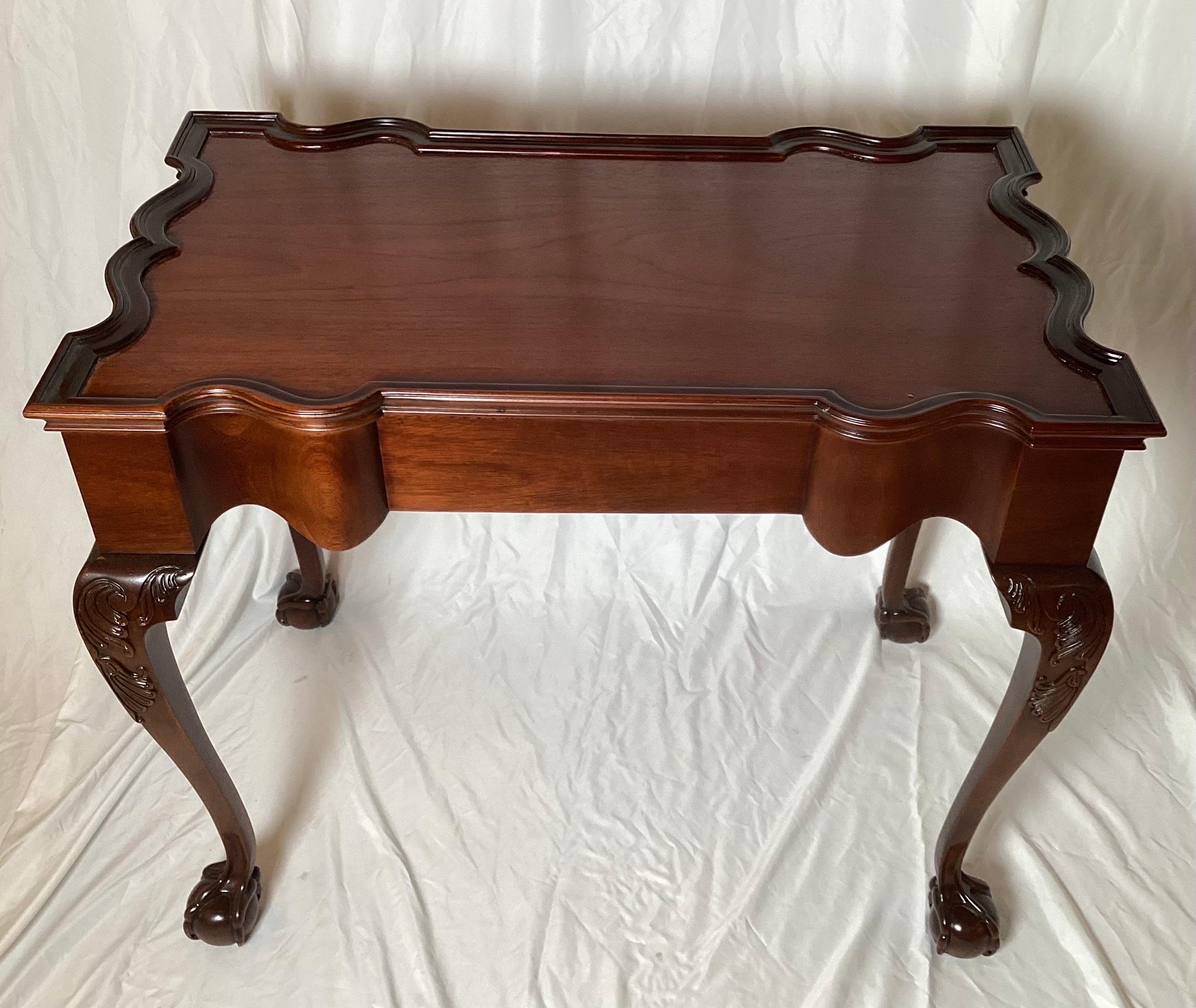 A beautiful reproduction tea table of the famous Newport Rhode Island John Goddard rectangular pie crust edge table.  Elegant shape and proportions with the classic carved legs with ball and claw feet with the talon claw opening around the ball