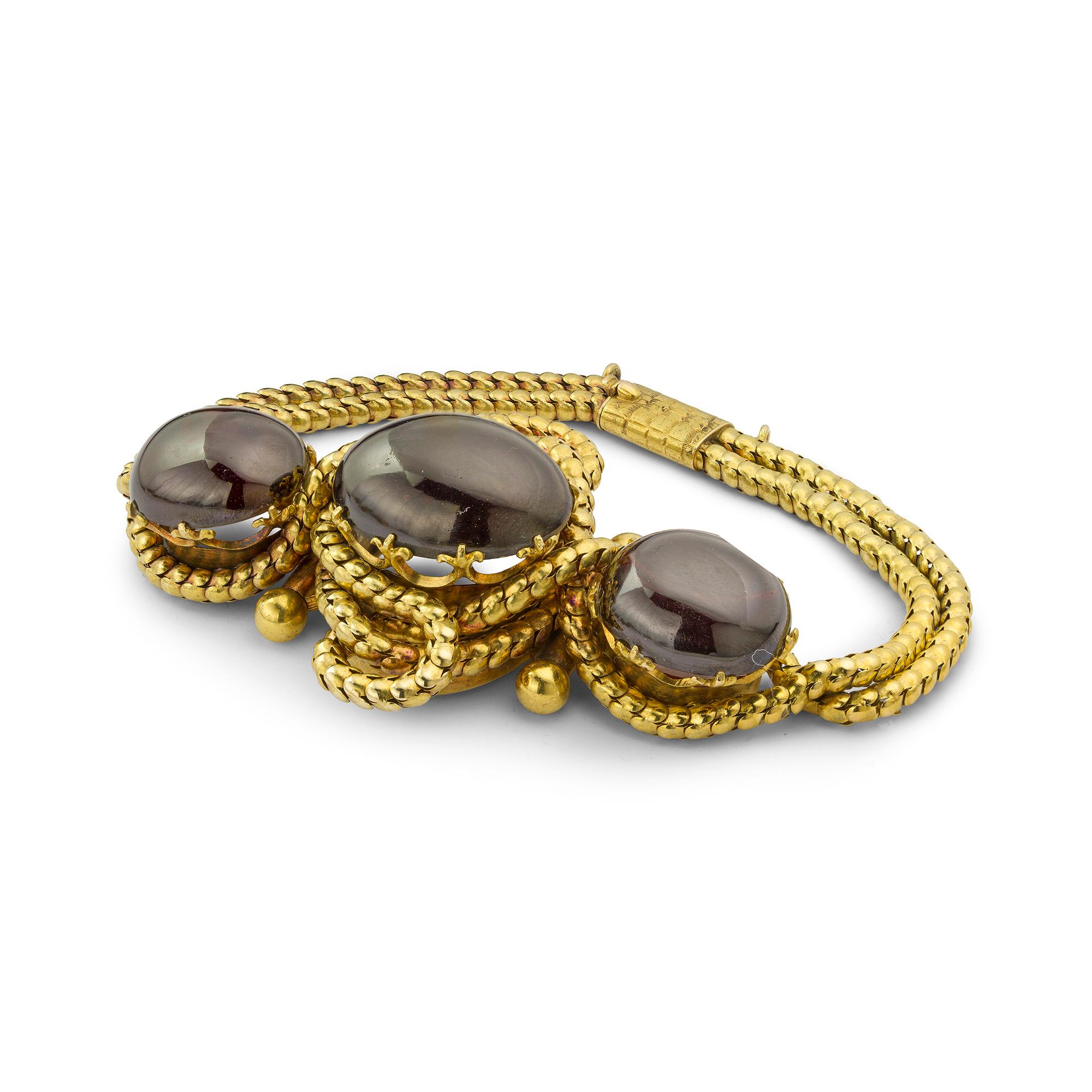 Ein viktorianisches Cabochon-Granat-Armband, der zentrale ovale Cabochon-Granat flankiert von zwei kleineren ovalen Cabochon-Granaten, die jeweils in Fleur-de-Lis gestaltete Krallen eingefasst sind, umgeben von einer geknoteten Goldkette in einer