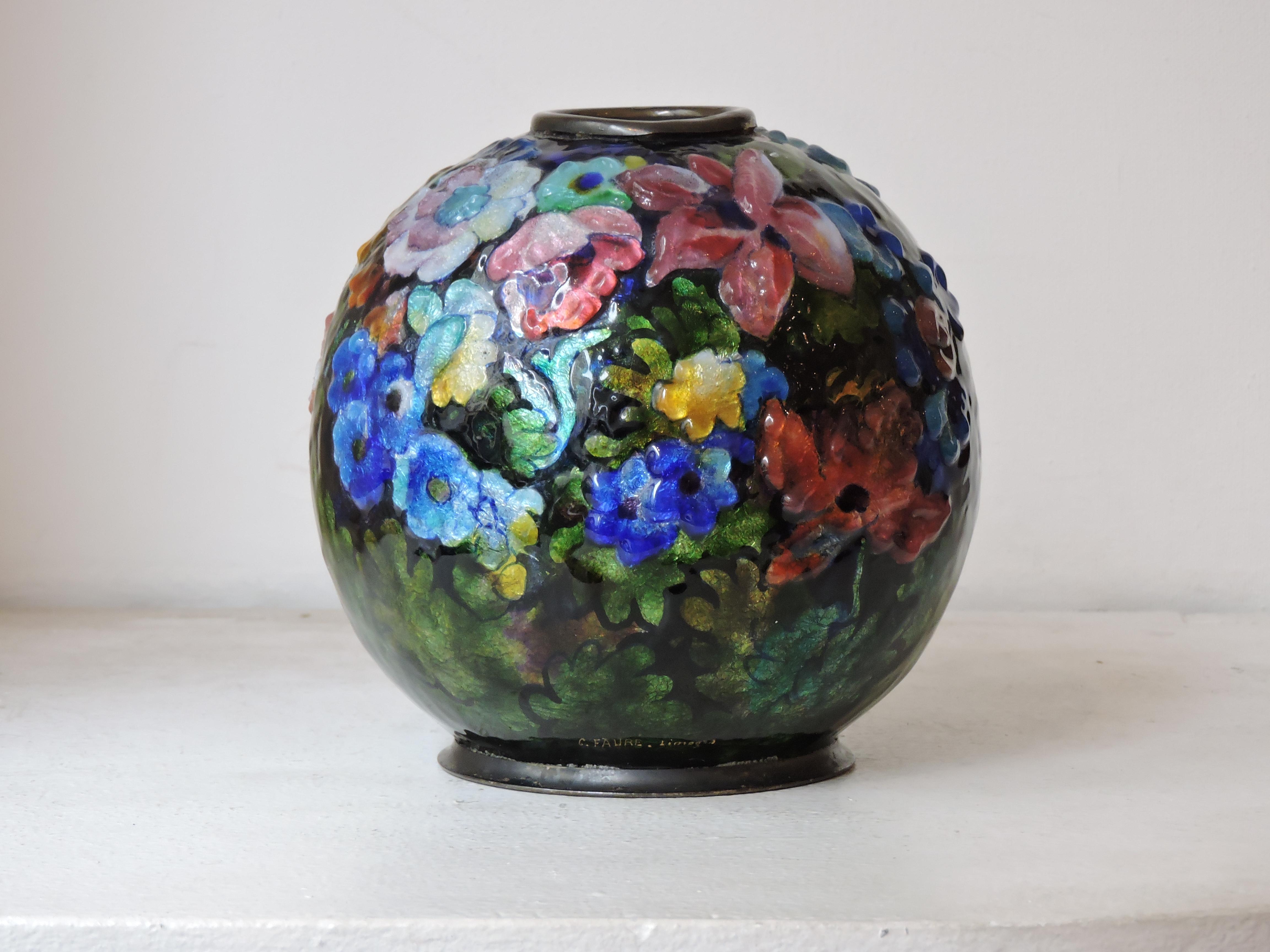 A Spherical vase by Camille Faure (1874-1956) made of hand applied polychromed enamel over a copper body depicting a beautiful flower scene in slight relief.
Brass collar and base,
circa 1930 
Signed C. Faure Limoges.

 