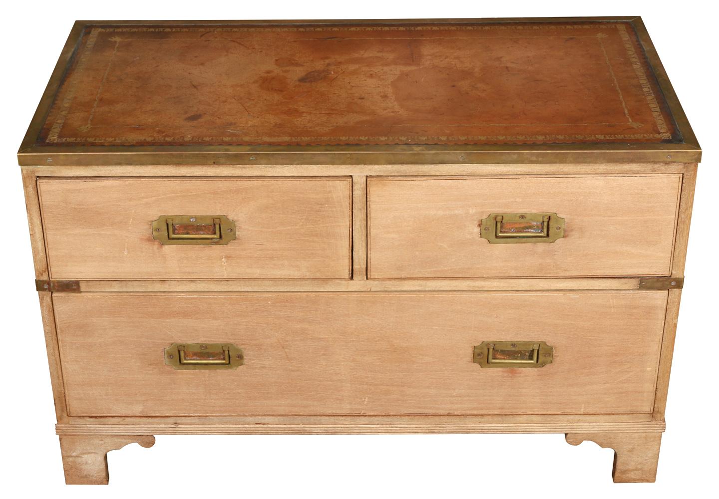 A unique example of campaign furniture, this low chest could be used in many ways--as a coffee table, a side table or even at the foot of a bed. It has a bleached mahogany finish, with a tooled brown leather top and brass hardware, and is raised on
