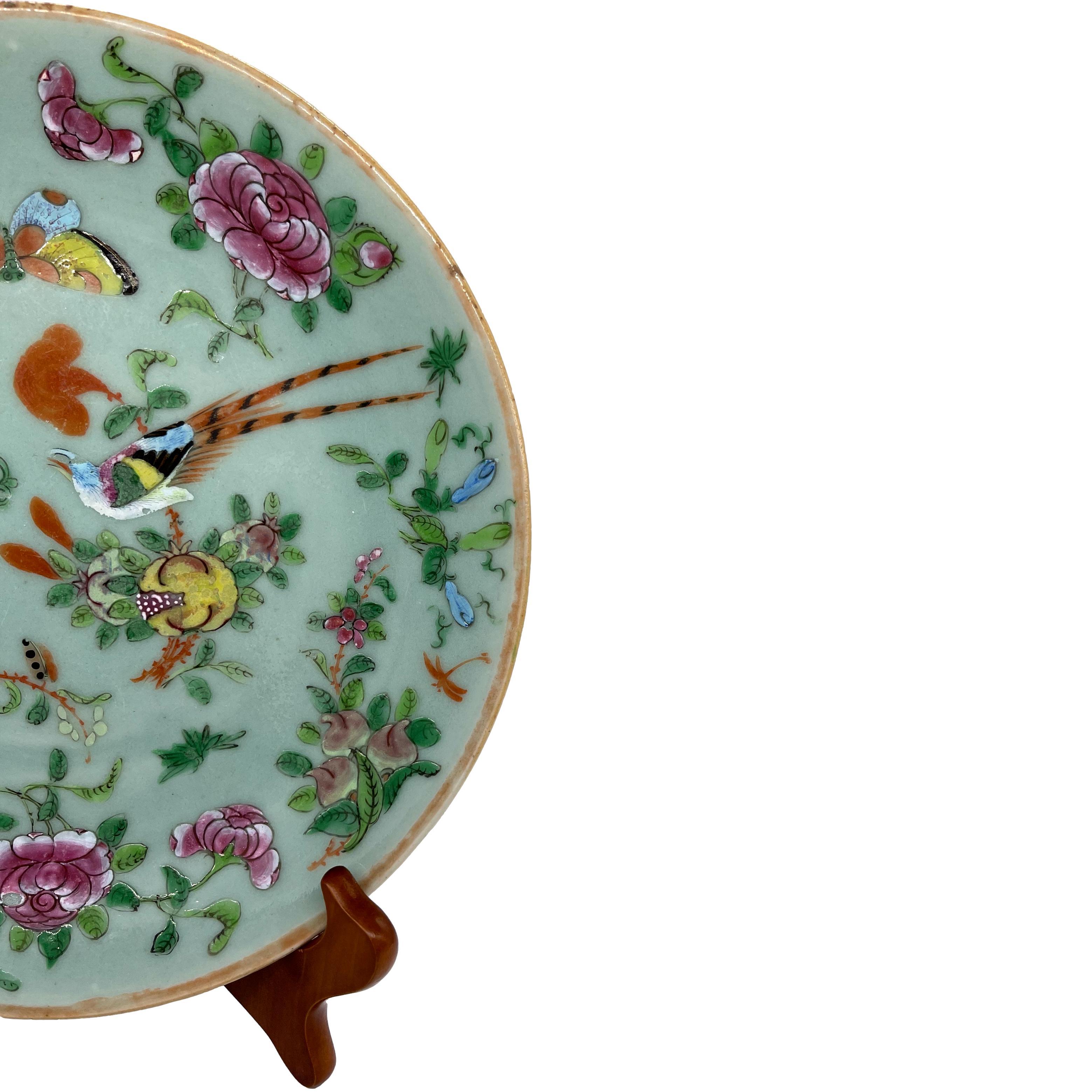 A Canton Famille Rose Chinese Export Porcelain 10-inch Plate, the polychrome enameled surface with a colorful pheasant, butterflies, and a single iron red-glazed dragonfly, among fruit and floral sprays on a celadon blank, the reverse with blue