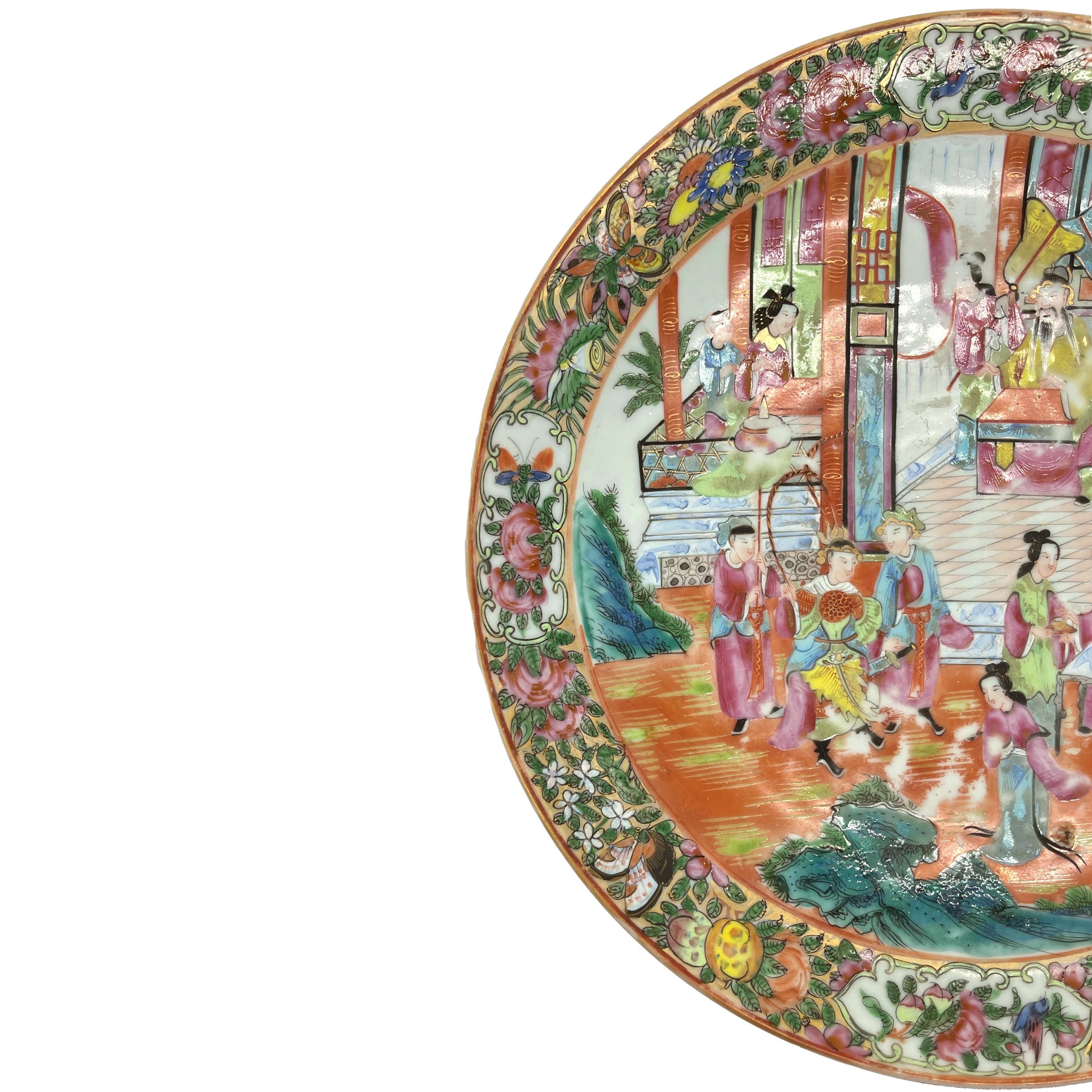 A Canton Famille Rose 12.75-inch charger, the polychrome enameled surface depicting an active palace scene with a distinguished warrior and attendants being presented to the Emporer, the border with an arrangement of butterflies, flowers, and fruit