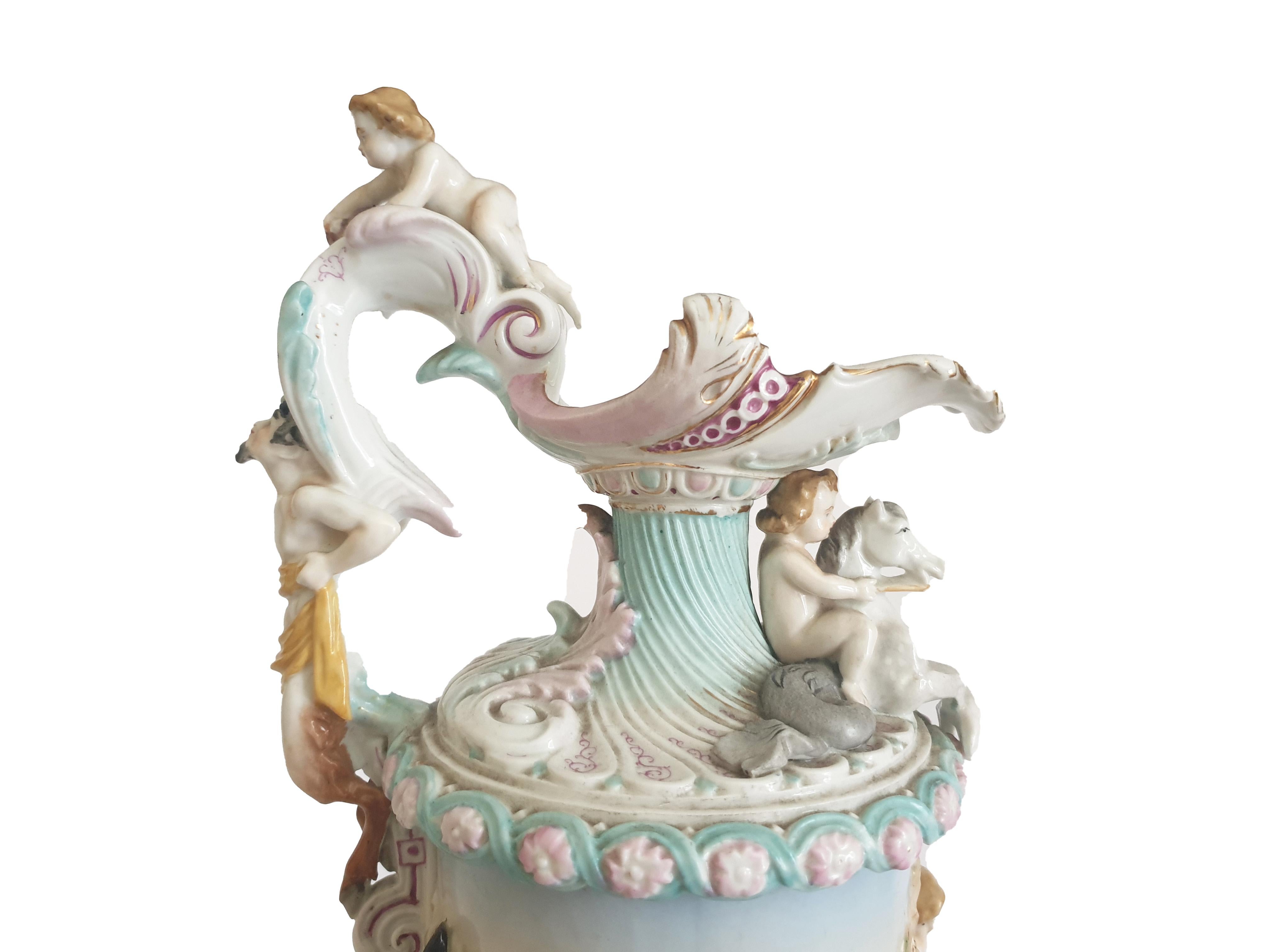 This beautiful antique Porcelain Figural Ewer is handcrafted by the Italian factory Capo de Monte and dates back to around circa 1900's. 
The ewer is elaborately and profusely modeled in the Capo de Monte palette and this design features festive
