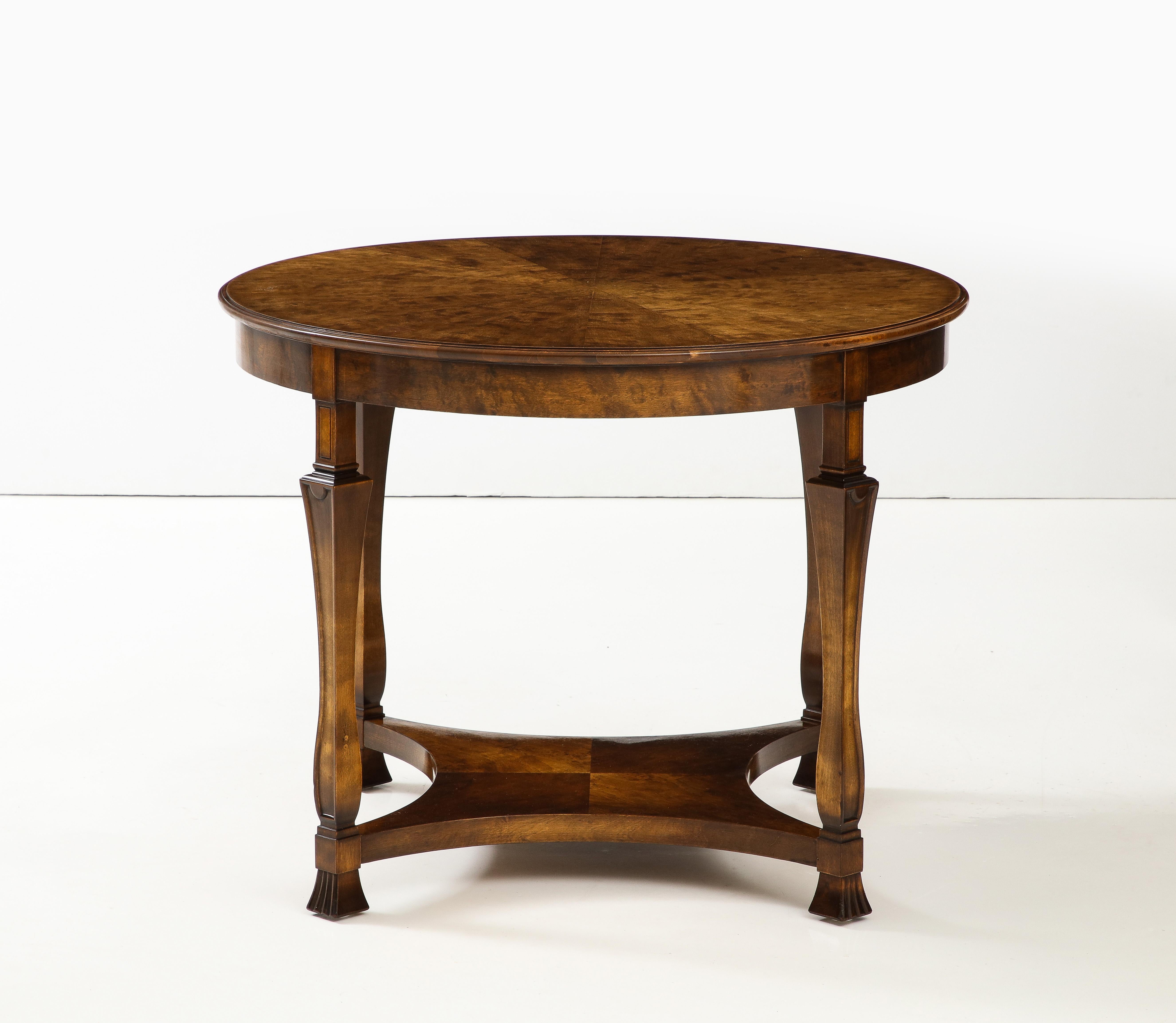 A Swedish Grace birchwood and stained side table, Designed by Carl Malmsten, circa 1940s, with a circular sunburst veneered top above a conforming apron raised on square tapered and channeled legs ending with flared feet joined by a concave