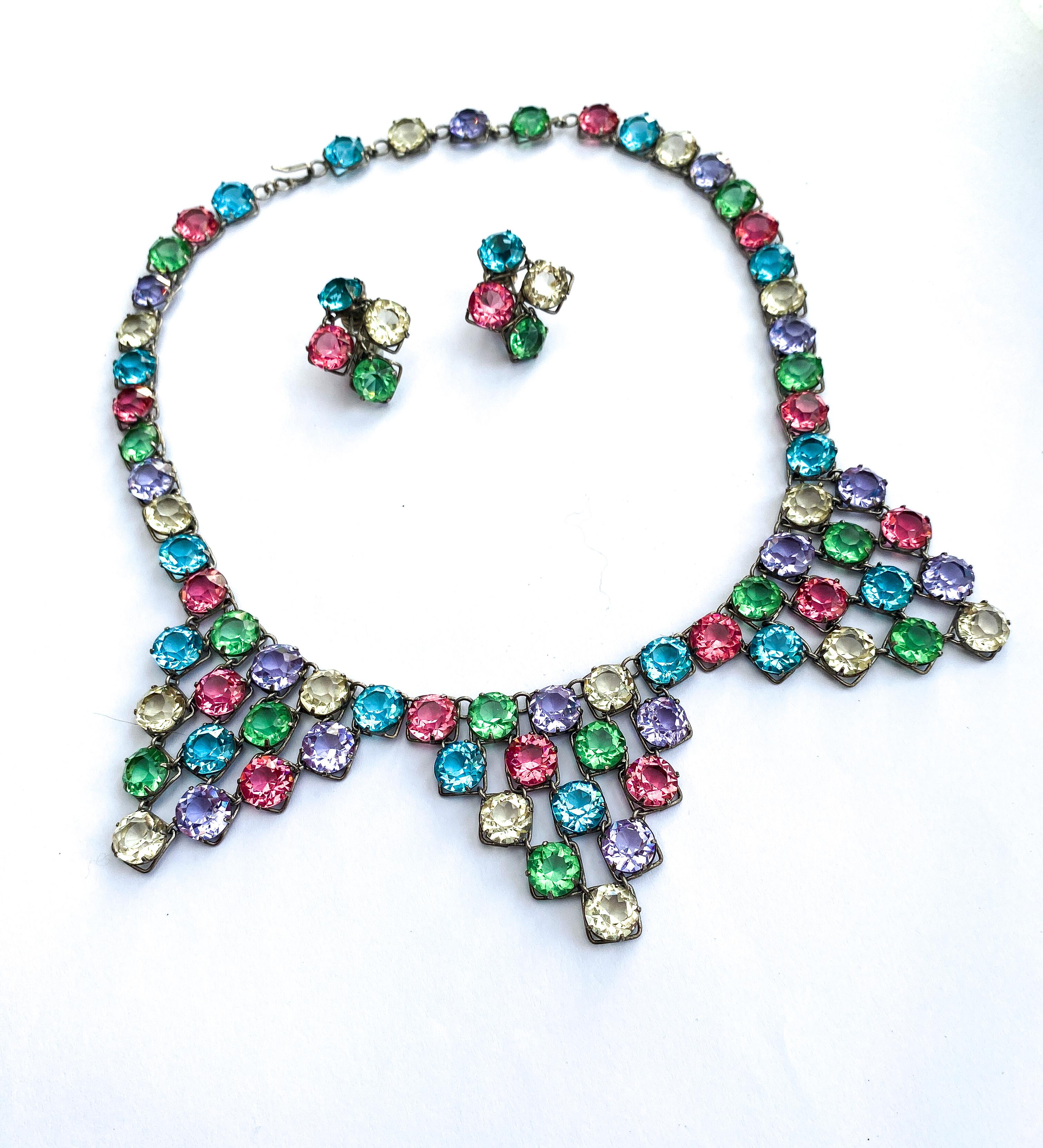 A bright and cheerful necklace and earrings set, with a soft and pretty colour combination, soft greens, lilacs, aquas, citrines and pinks, beautifully cut glass stones, all set in white metal. Made in Czechoslovakia, three triangular sections drop