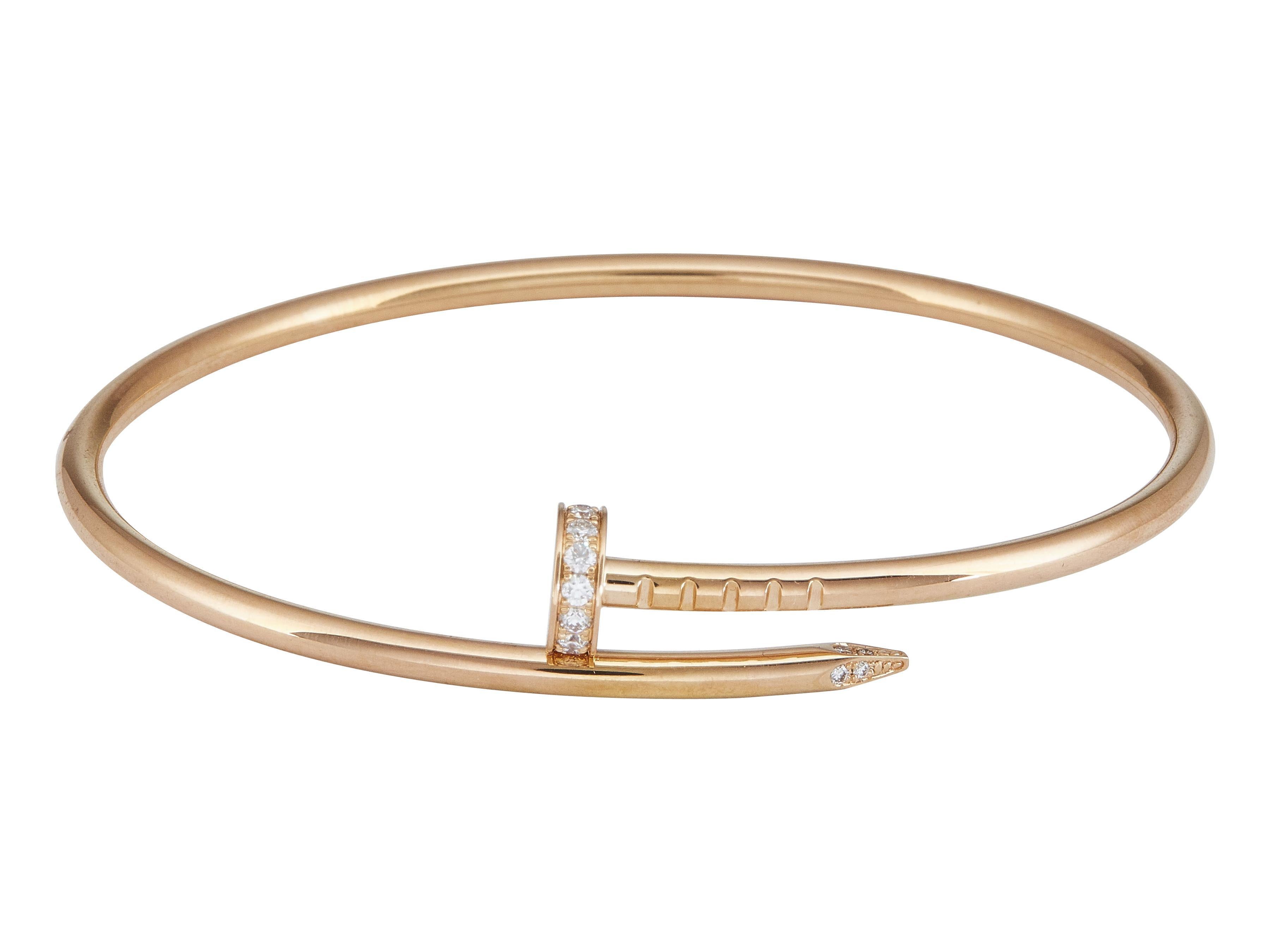 The bracelet: A Cartier Juste un Clou bangle bracelet. This small model is designed as a flexible nail, set with round brilliant cut diamonds in eighteen karat rose gold.

It is in good condition. The nail head is slight misaligned from the point of