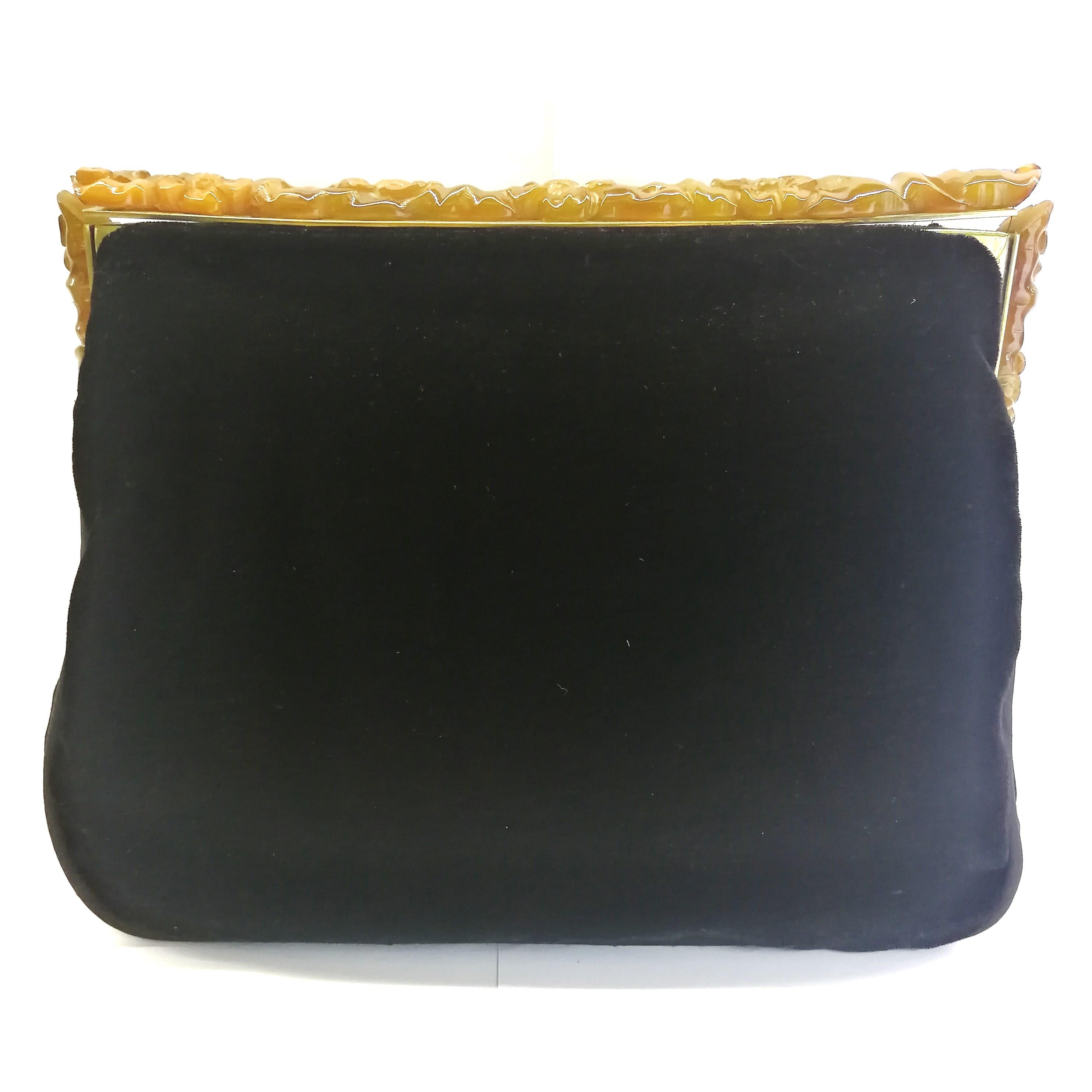 An intricately carved Bakelite frame from the 1930s, with stylised flower and branch motifs, is attached to a black silk velvet clutch , which is piped in black silk, to create this very smart and period clutch. Possibly German in origin, judging by