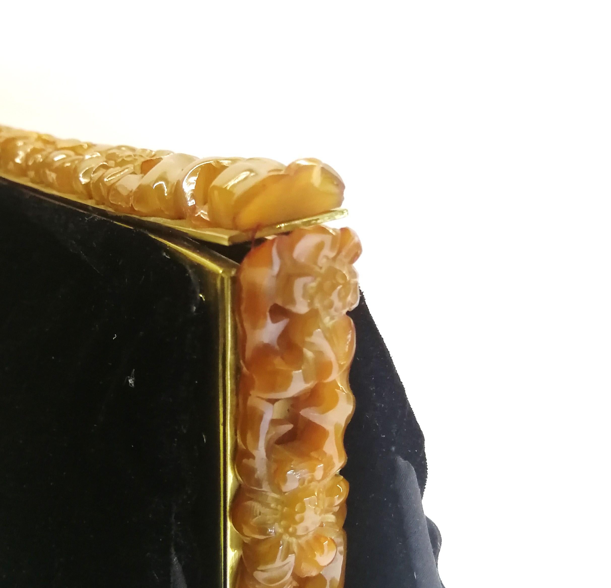 Black A carved amber Bakelite frame, and silk velvet clutch/handbag, 1930s.