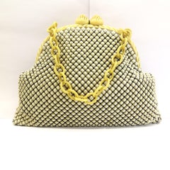 A carved Bakelite framed and cream enamelled mesh handbag, 1930s.