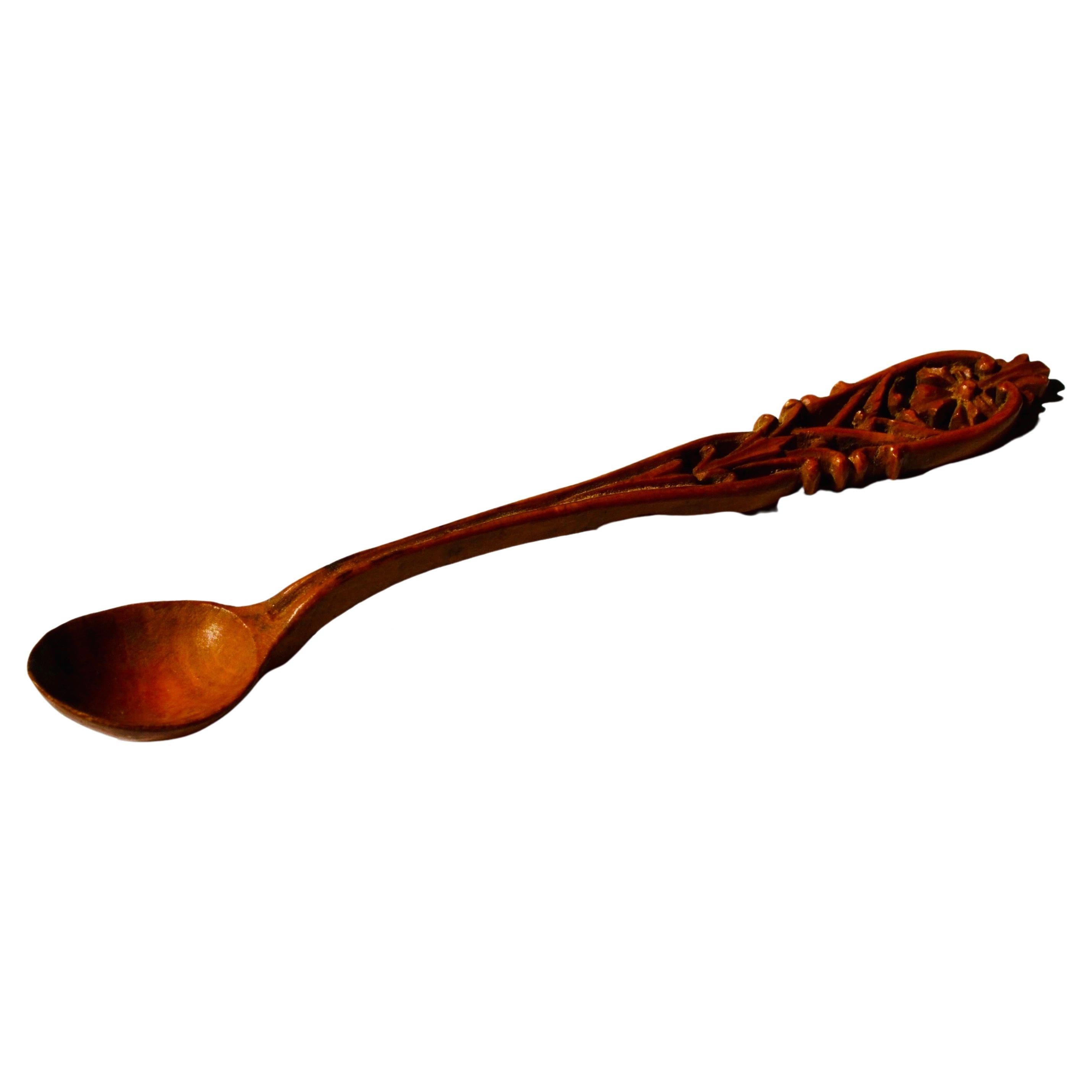 Carved boxwood spoon, likely from the late 19th century, handcrafted in France as a monoxylous piece with a beautiful patina. Fine example of French folk art, showcasing traditional craftsmanship. Perfect for collectors or enthusiasts of antique