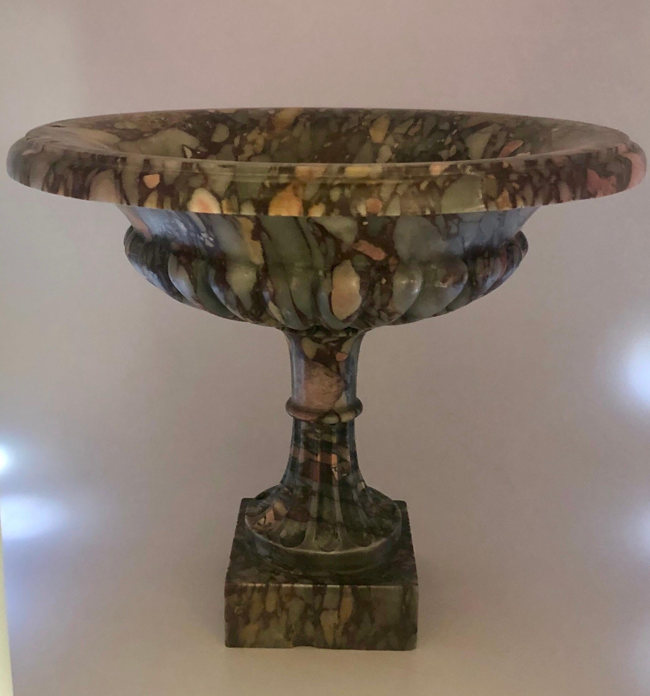 The Tazza with a raised floral carving in the center of the cup with gadrooned decoration around the cup with tapering stem and half fluting. Ending in small square base. Minute chip to base. See photos.