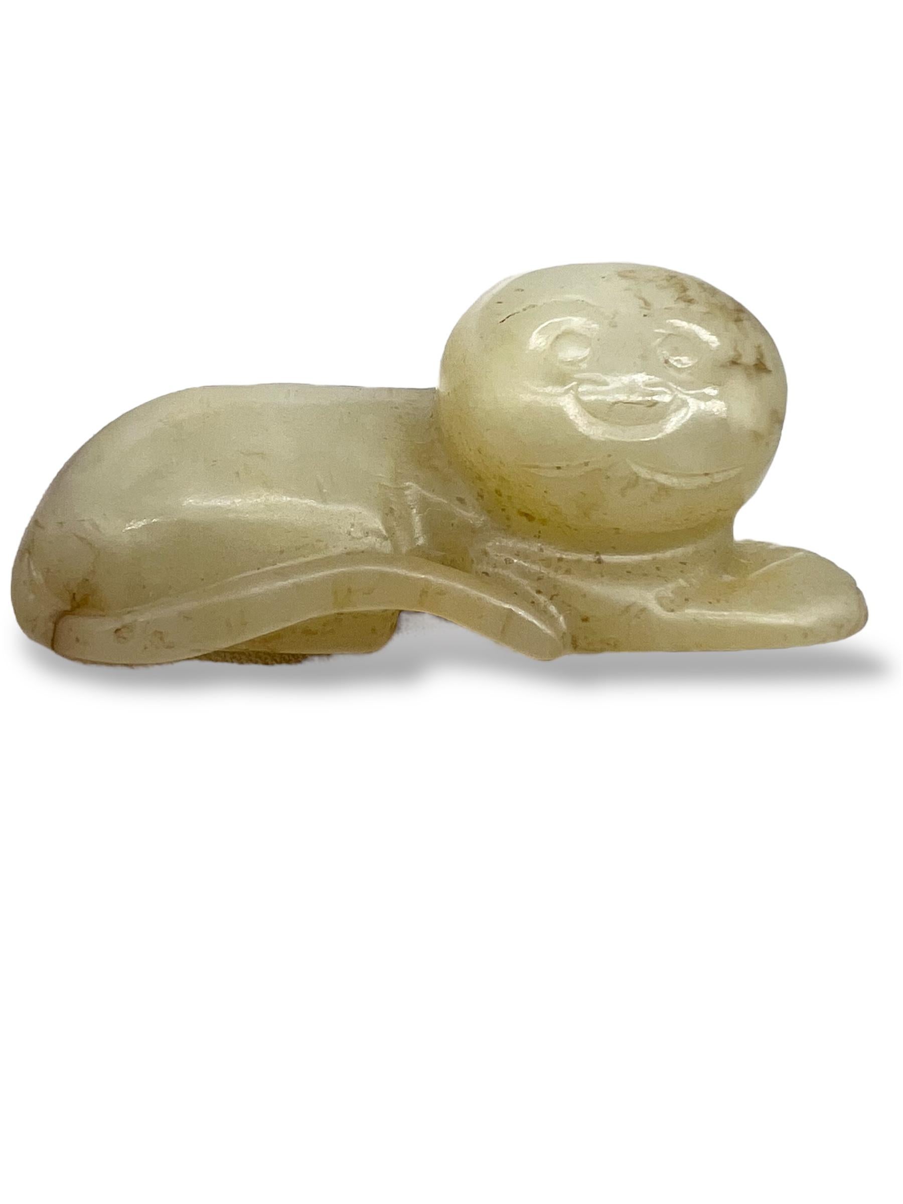 Figura di gatto supino intagliata in giada celadon
Cina, dinastia Qing (1644-1912) o successiva

Finemente scolpita da un unico pezzo di giada celadon con una morbida traslucenza e inclusioni naturali, questa affascinante scultura rappresenta un
