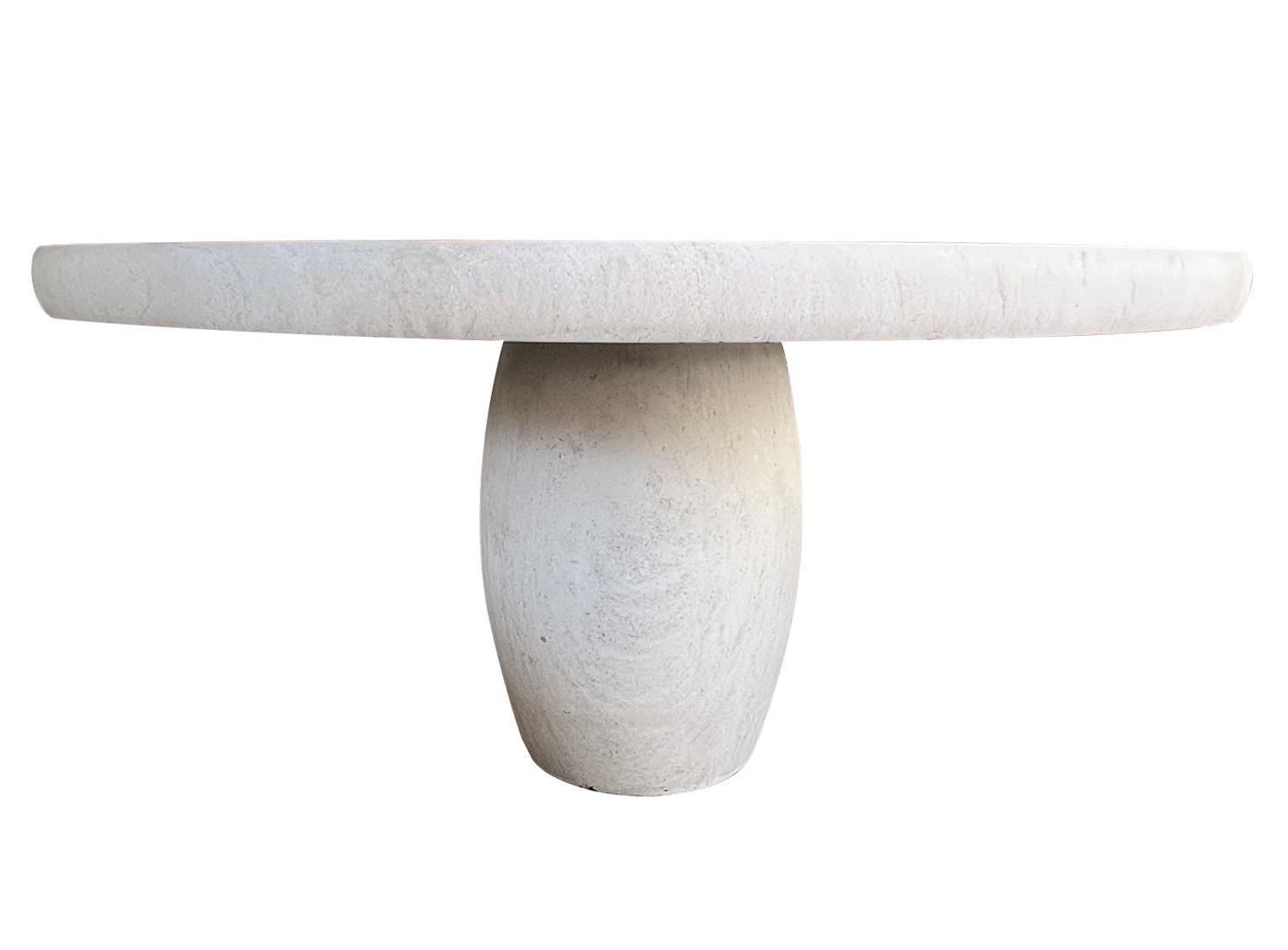 Fabriquée en France à partir de pierre calcaire française, la table se compose d'un épais plateau rond à bord arrondi et d'un support en forme de tonneau. Neuve avec seulement une usure minimale attendue ; la table est idéale pour les projets