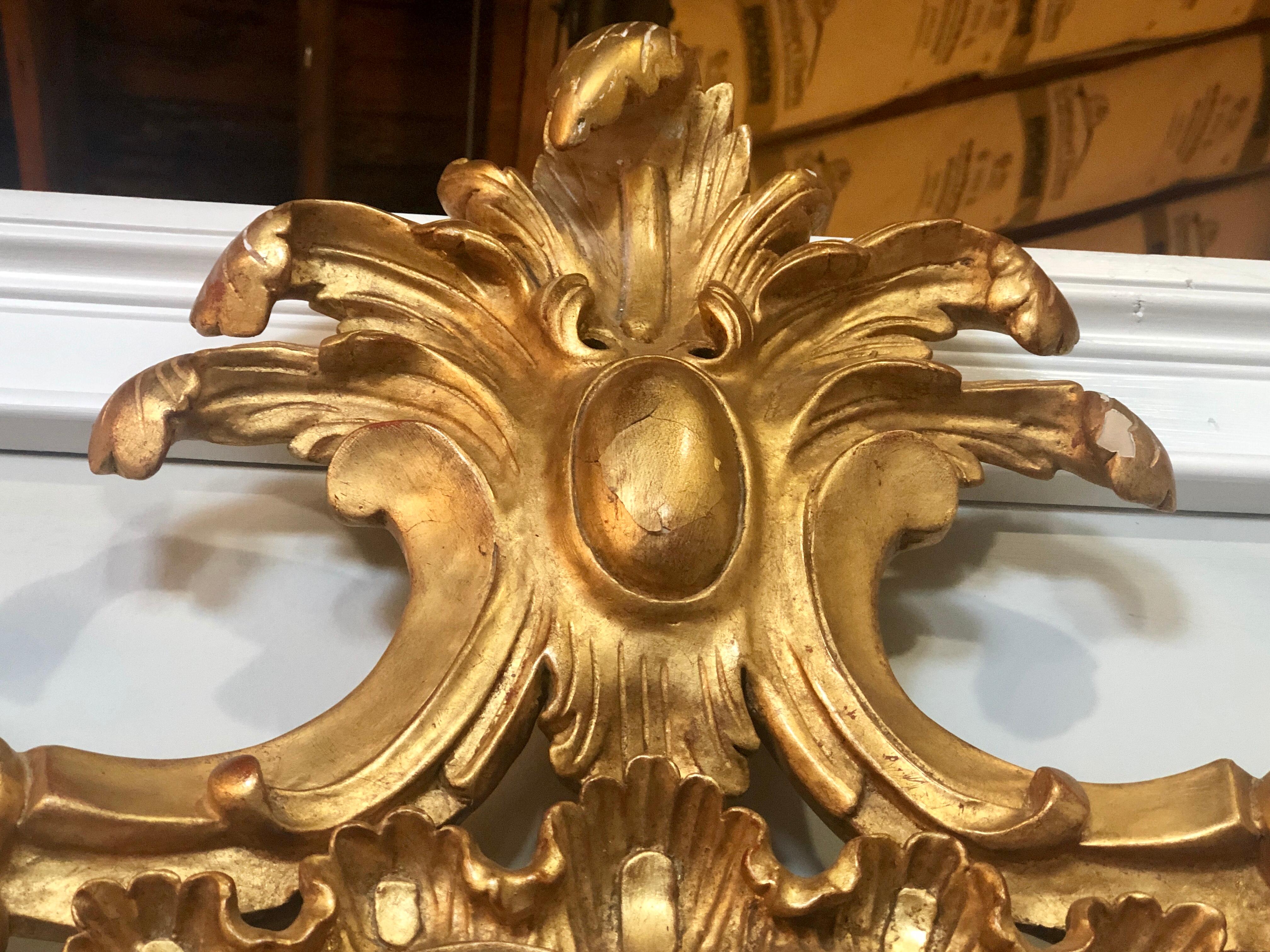 A carved gilt gold leaf Italian wall or console mirror in Rococo Renaissance form.