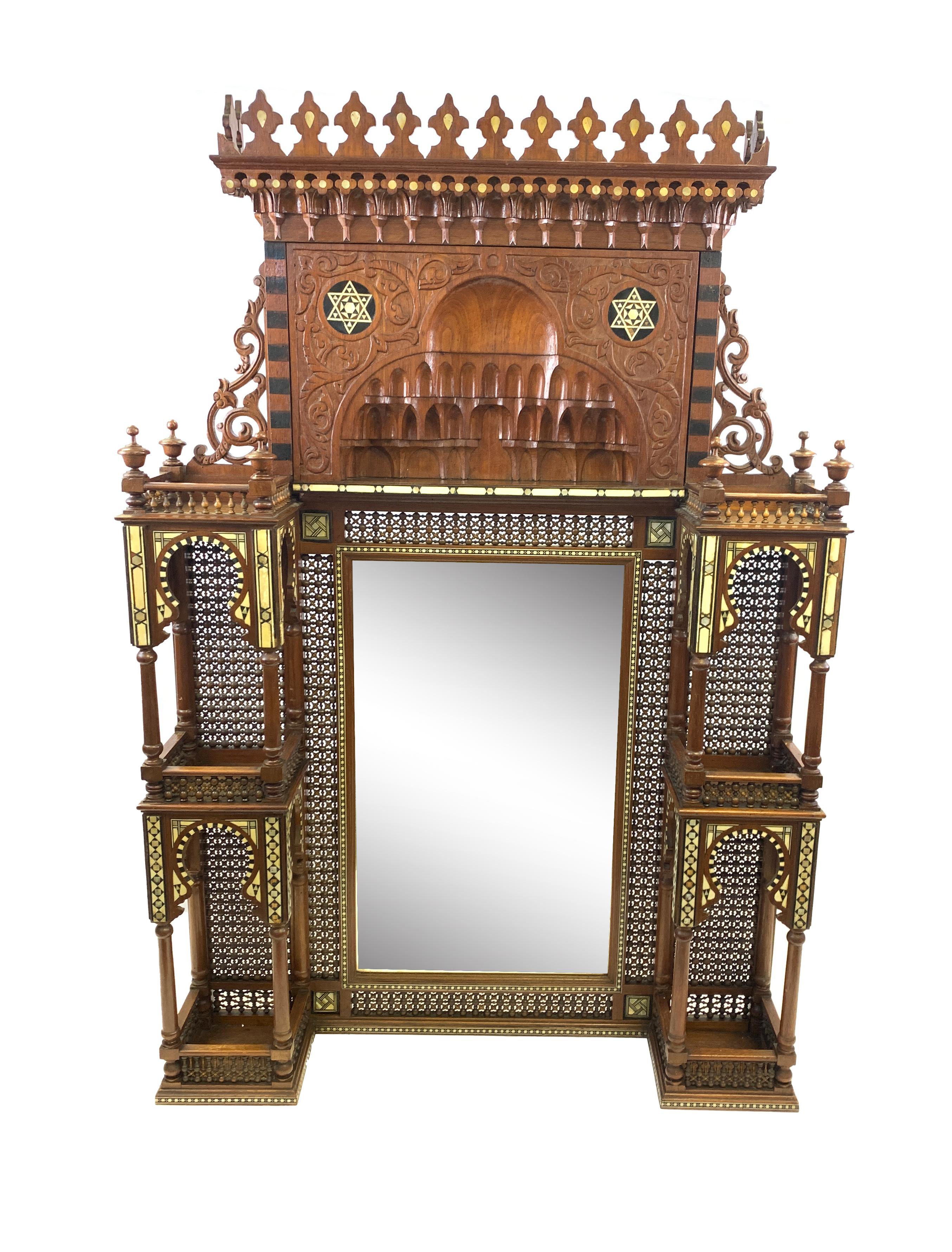 Hanging mirror of rectangular shape, wooden frame engraved in the Alhambra manners, with two shelves divided on three levels.
 