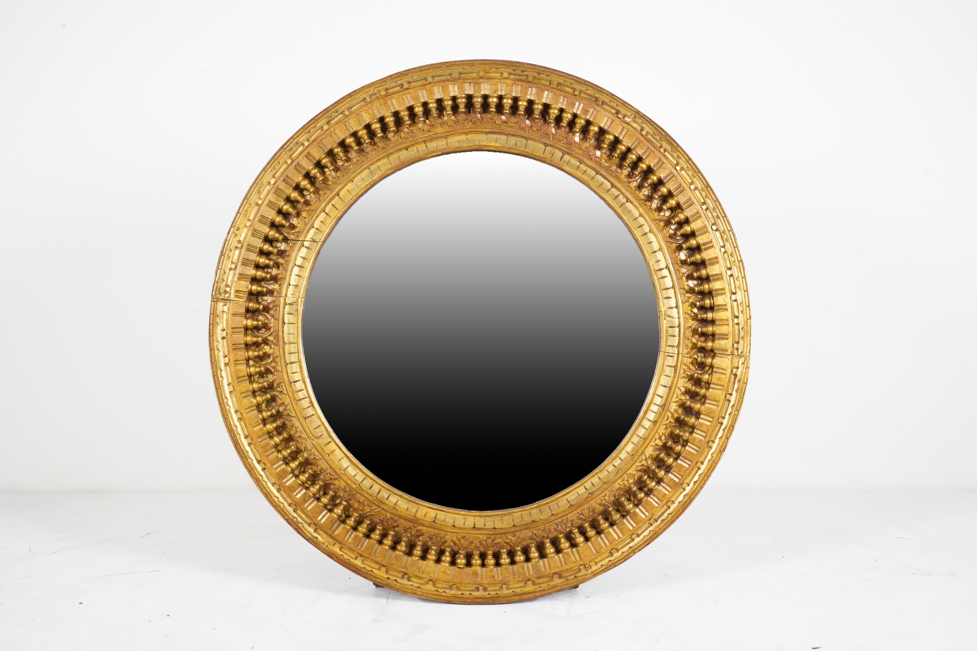 This large and intricate mirror frame was hand-carved from mango wood in India according to an 18th Century Mogul design. The piece is newly-carved and painted in gold pigments. The glass mirror is new and in perfect condition.
