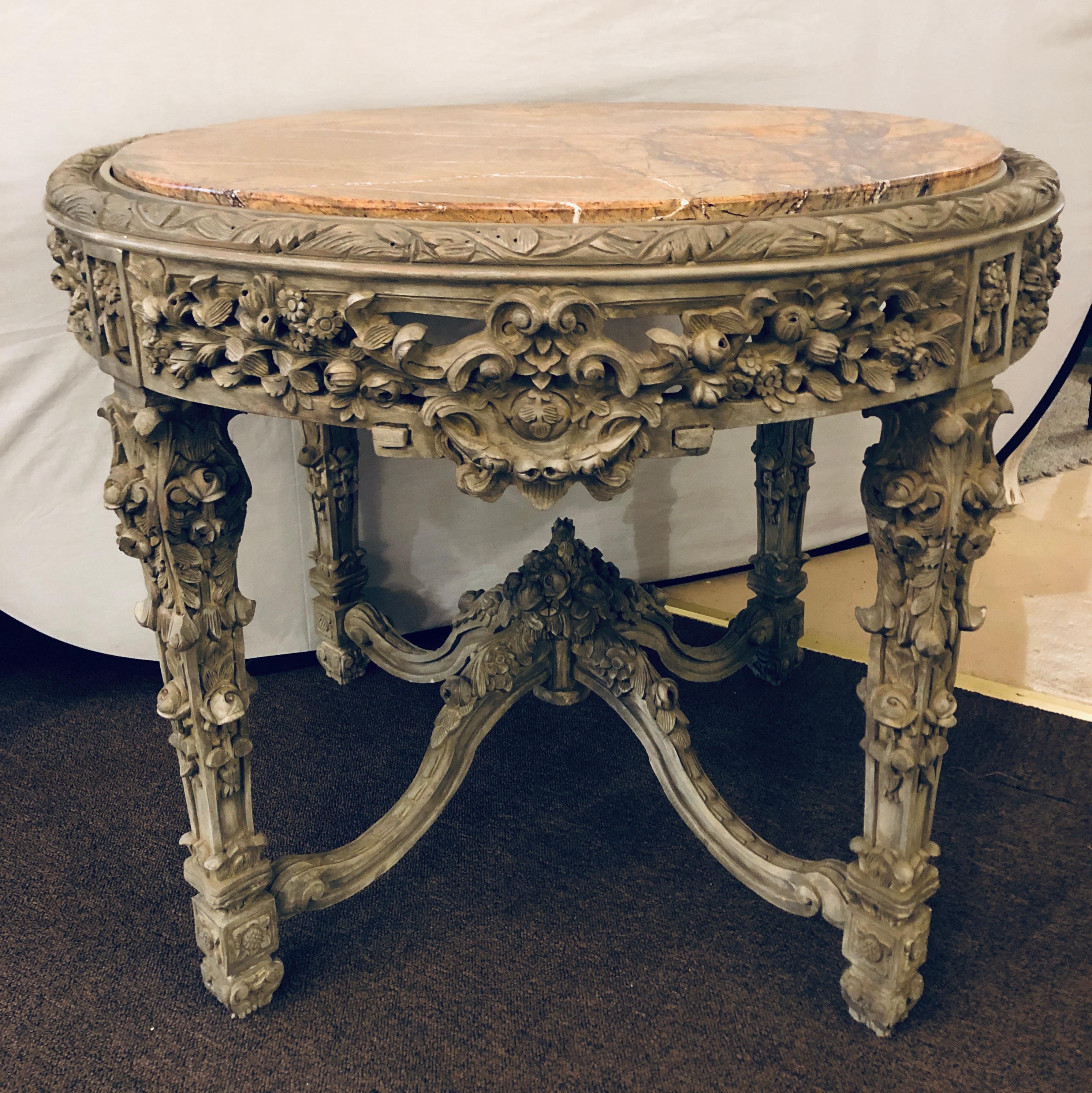 A carved marble top rose and grape with leaf decorated center, dining or end table. The base supporting a large circular marble top. The whole with a wonderfully decorative carved undercarriage supporting a finely carved exceptional table base.