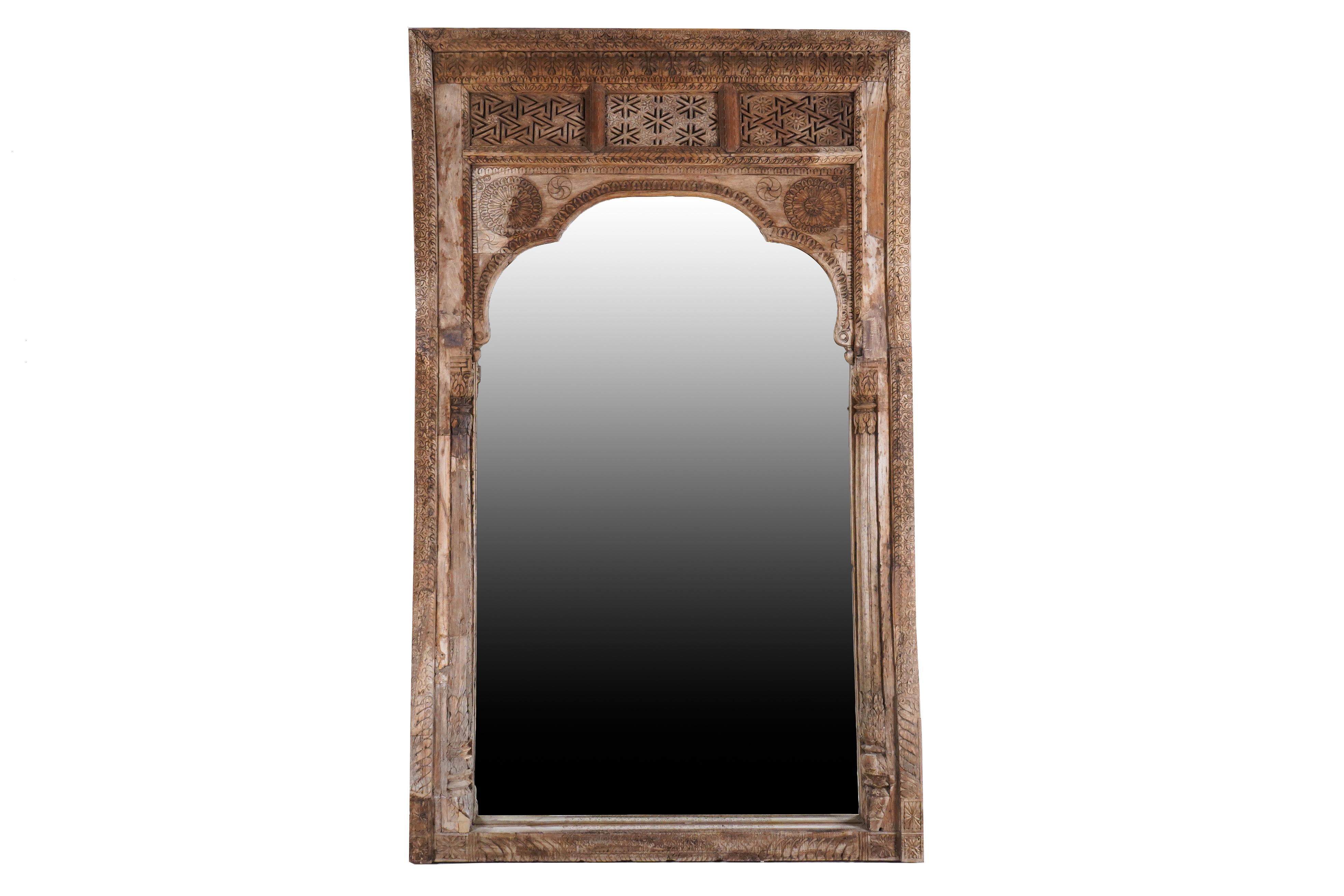 This intricately carved mirror frame was originally a window frame in a magnificent mansion in Gujarat, India. It is made from Sheesham wood and was originally painted. After the mansion was dismantled, all the valuable wooden decorations