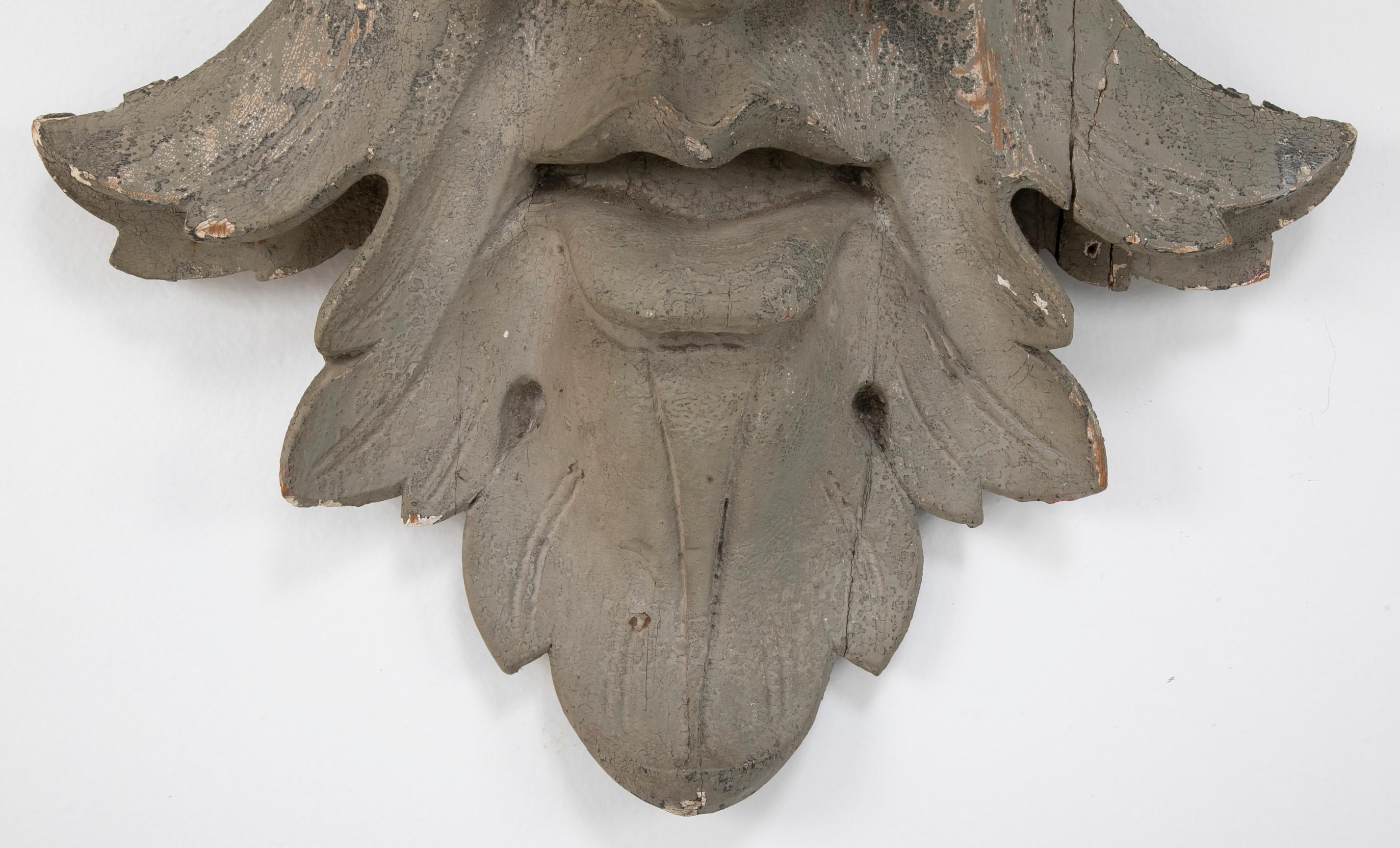 Geschnitztes und bemaltes Architekturelement aus Holz in Form einer Maske 