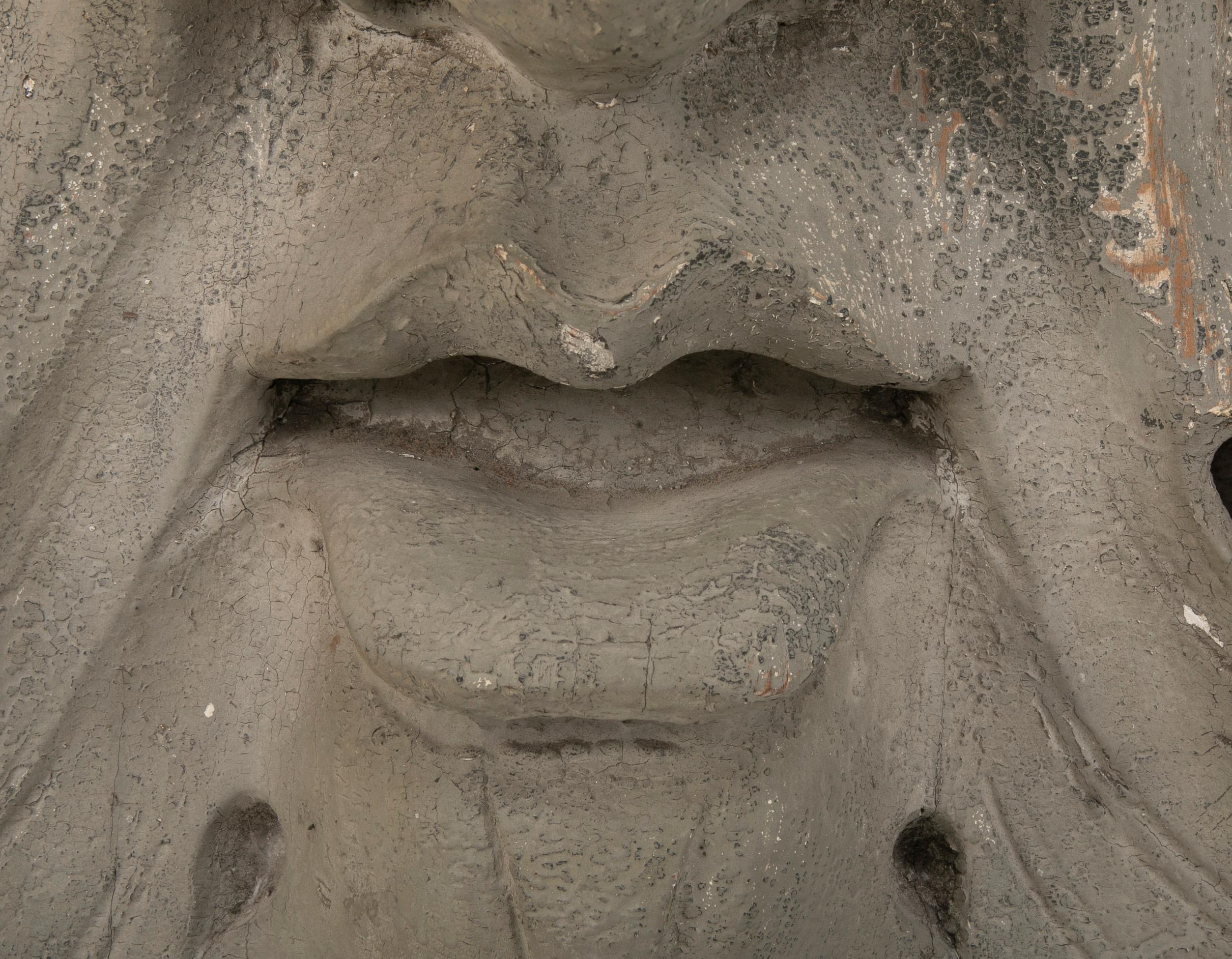 Bois Élément architectural en bois sculpté et peint sous la forme d'un masque 