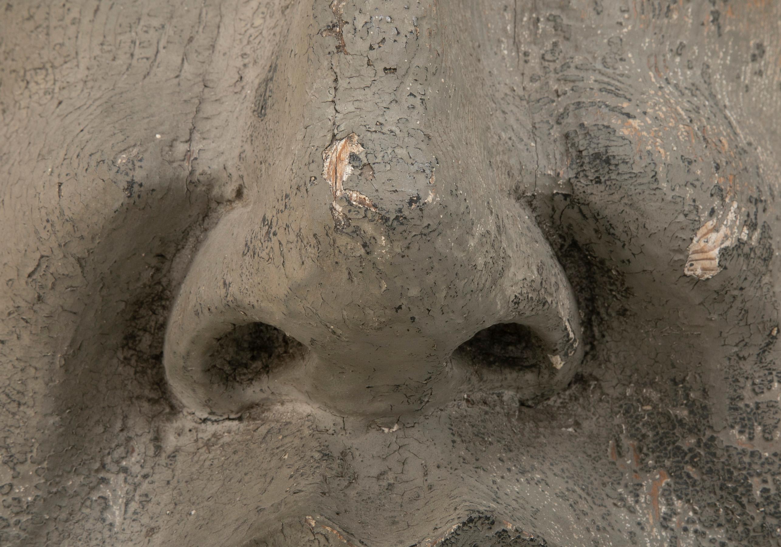Geschnitztes und bemaltes Architekturelement aus Holz in Form einer Maske 