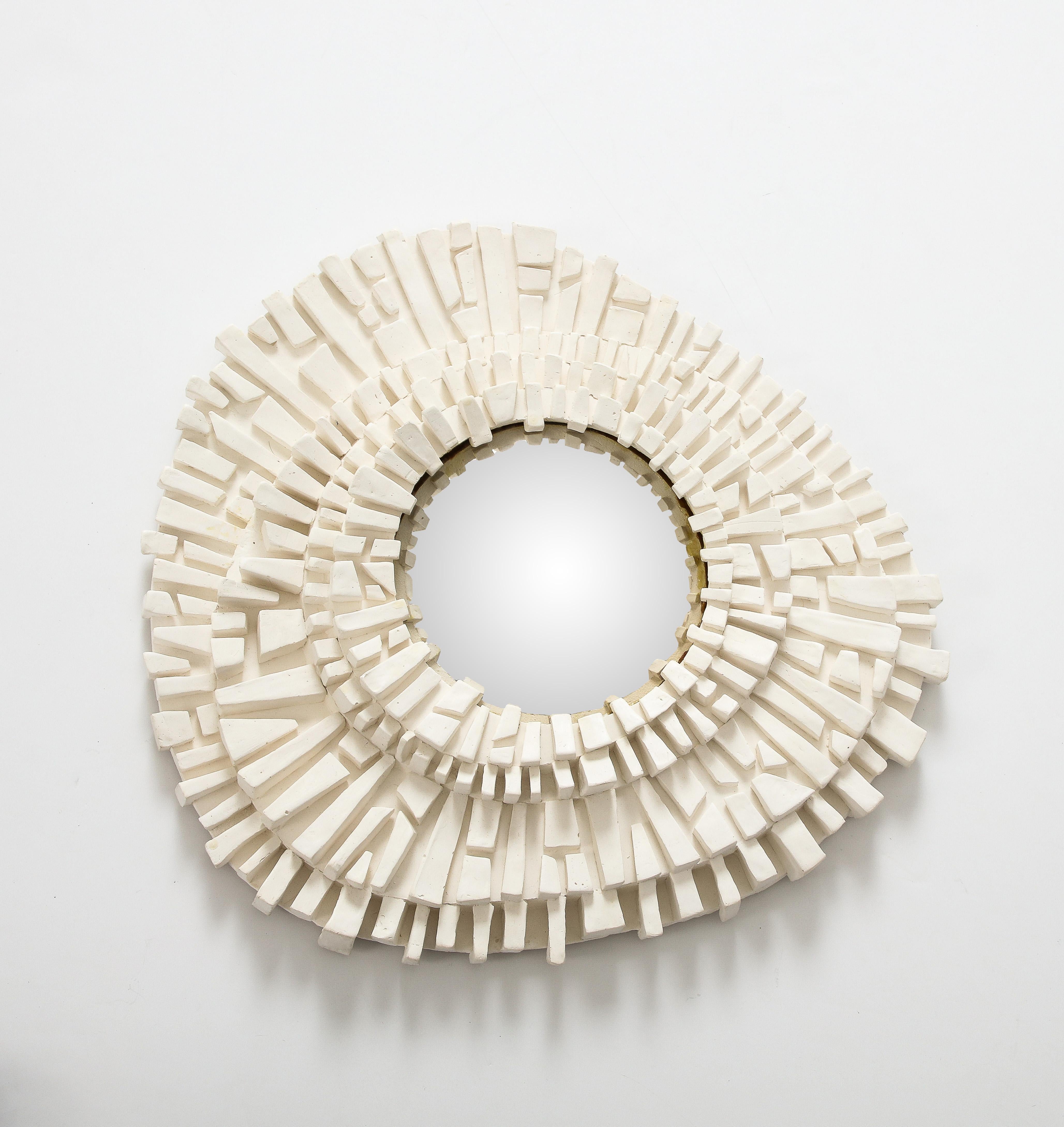 Faisant partie d'une série dans notre inventaire, ce miroir en plâtre sculpté avec verre convexe est stupéfiant seul ou dans le cadre d'une collection  Sa forme asymétrique et sa texture intéressante en font une pièce unique, adaptée à un cadre