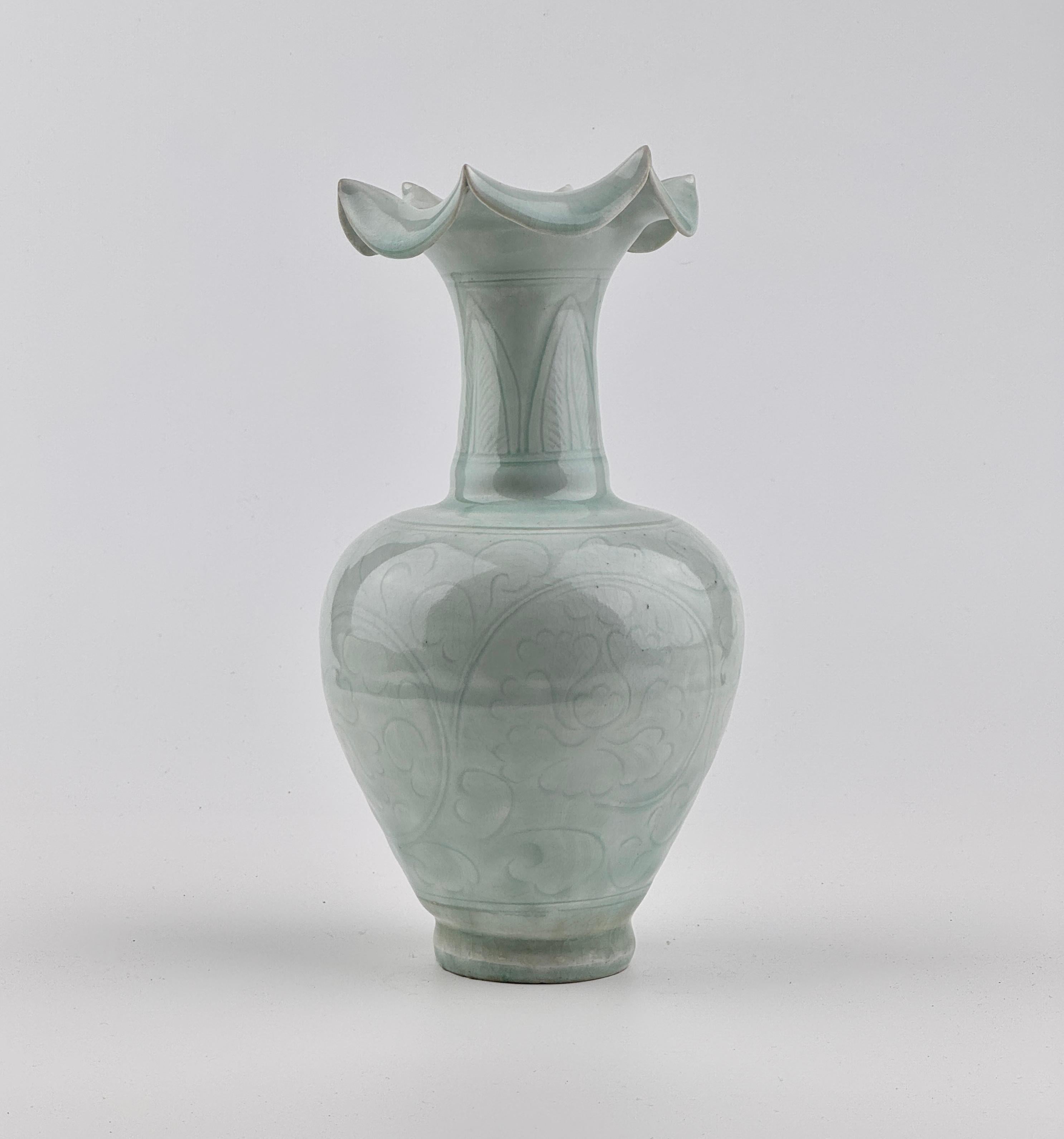 The ovoid body to a tall neck, the body decorated with a chrysanthemum meander, covered overall in a translucent pale blue glaze. Traces of excavation can be seen in the dirt marks on the lower part. Even when observed under a microscope, traces of
