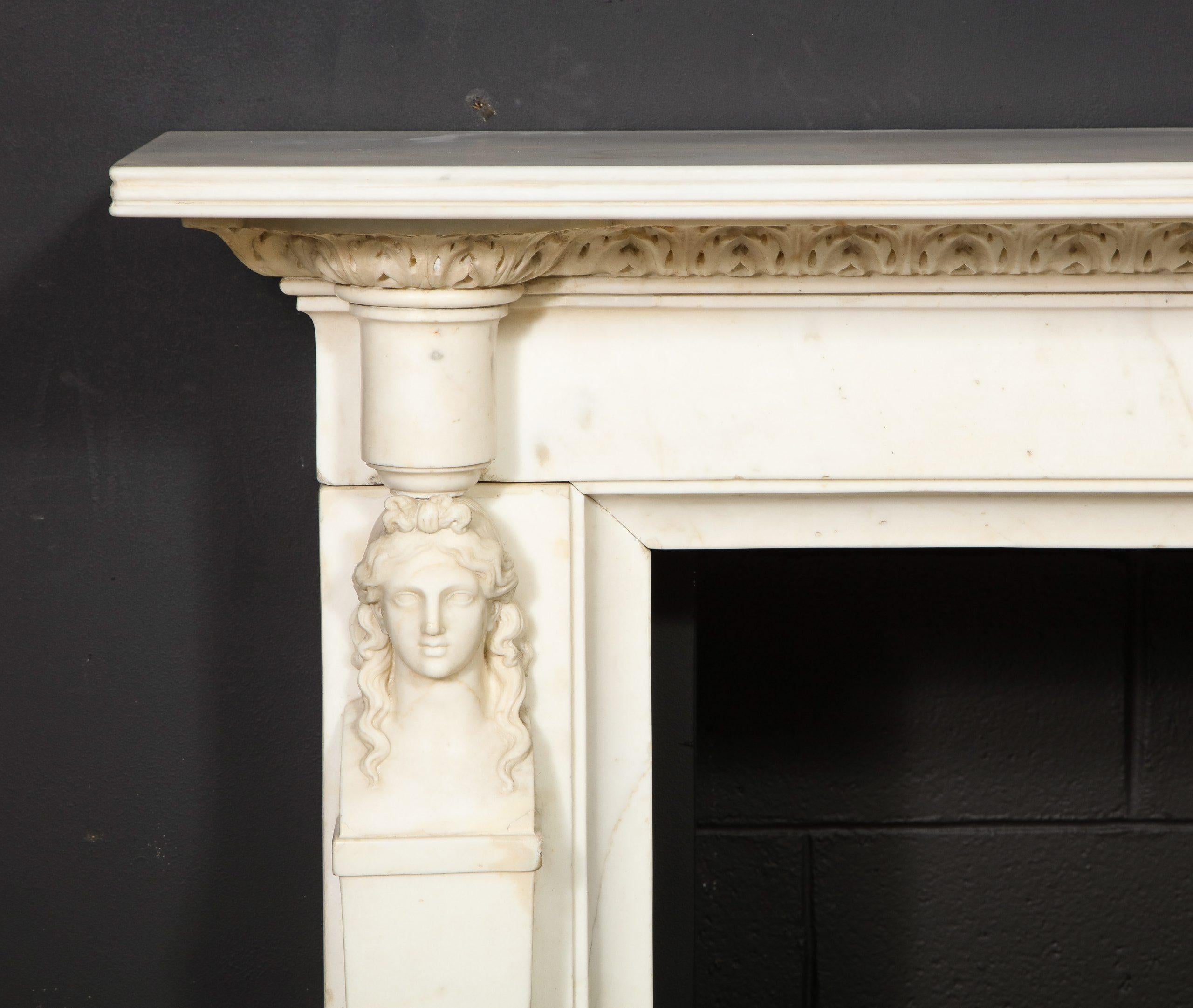 A beautiful English Regency Mantel, carved in statuary marble with two female caryatid figures that support the reeded shelf and frieze which is carved with bold acanthus leaf relief. 
Overall Dimensions of the Mantel: 67